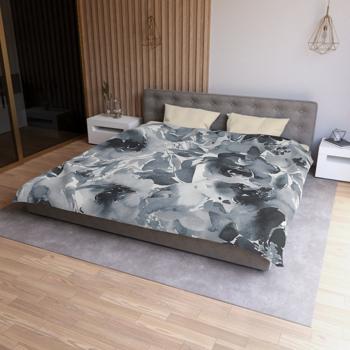 a modern bedroom with a gray tufted headboard, a gray bedspread with a floral pattern, and a white nightstand on the left side of the bed.