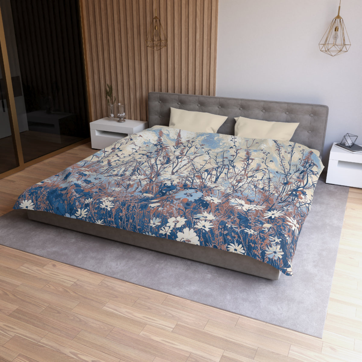 a modern bedroom with a large bed featuring a blue and white floral patterned comforter. The bed is positioned against a wall with a wooden panel, and there are two nightstands on either side of the bed. The room has a wooden floor and a gray area rug, creating a cozy and stylish atmosphere.