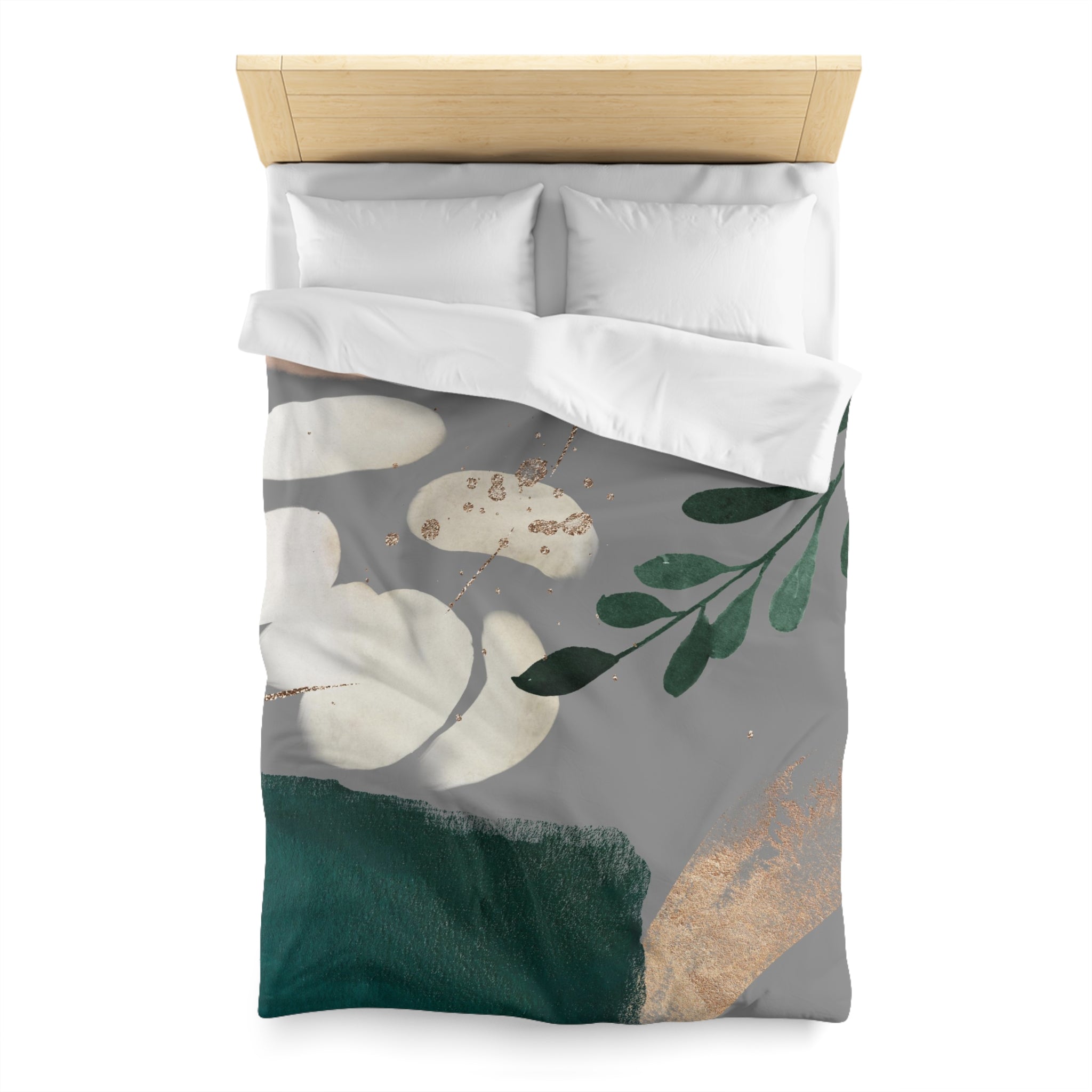 a bed with a gray and green floral patterned comforter and pillows.