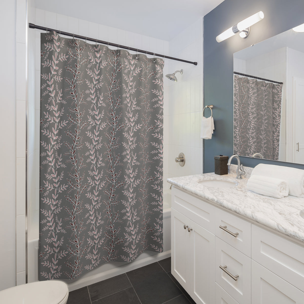 a modern bathroom with a white vanity, gray shower curtain featuring a leaf pattern, and a white sink with a marble countertop.