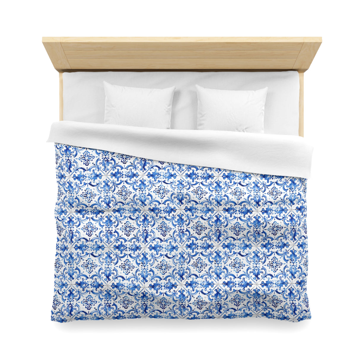 a neatly made bed with a blue and white patterned comforter and two white pillows.