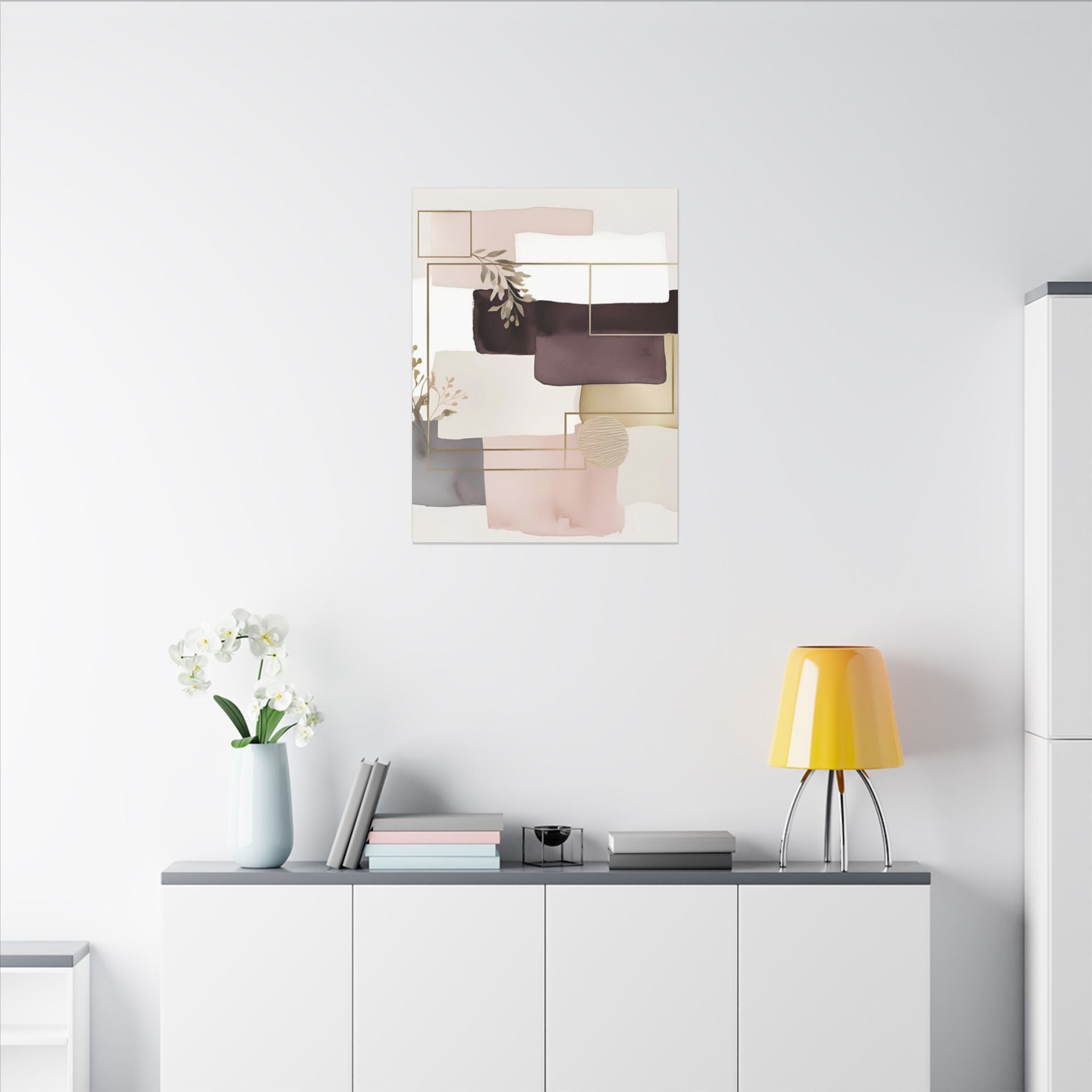 a minimalist living space with a white wall, a white cabinet, a yellow lamp, a vase with white flowers, and a framed abstract art piece hanging above the cabinet.