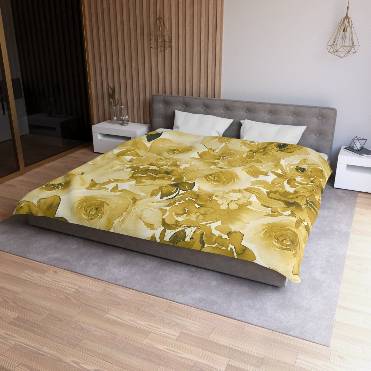 a modern bedroom with a large bed covered in a yellow floral comforter. The bed is positioned against a wall with a wooden panel. The room also features a nightstand, a pendant light, and a vase on a surface.