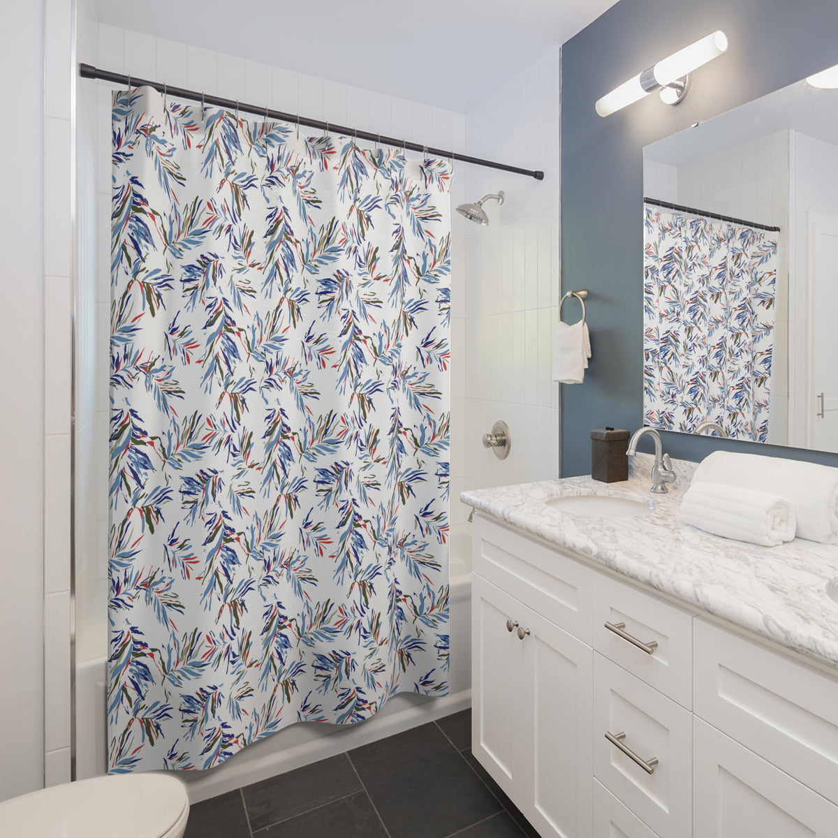 a modern bathroom with a white vanity, a shower curtain with a tropical print, and a mirror above the vanity.