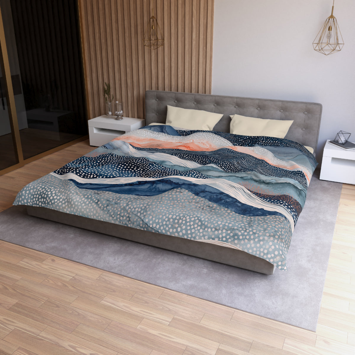 a modern bedroom with a large bed, a gray headboard, and a colorful patterned comforter. The room has a wooden floor and white walls, creating a clean and minimalist aesthetic.
