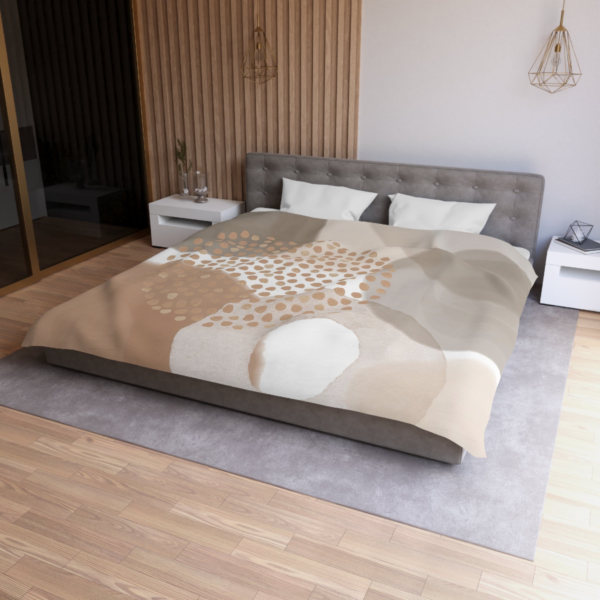a modern bedroom with a large bed, a gray headboard, and a neutral-colored bedspread featuring a pattern of circles and dots. The room has a wooden floor and white walls, creating a clean and minimalist aesthetic.