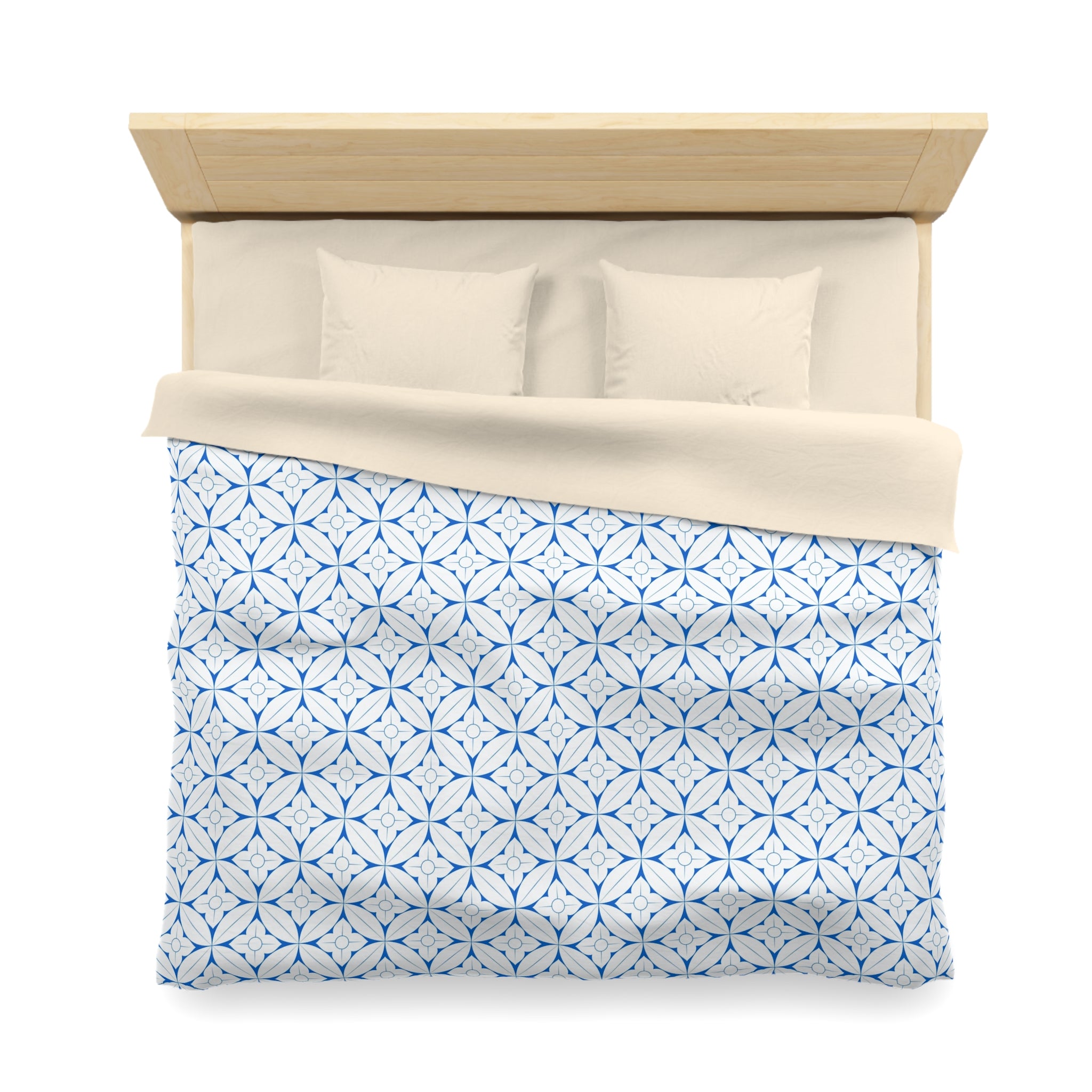 a neatly made bed with a blue and white patterned comforter and two pillows.