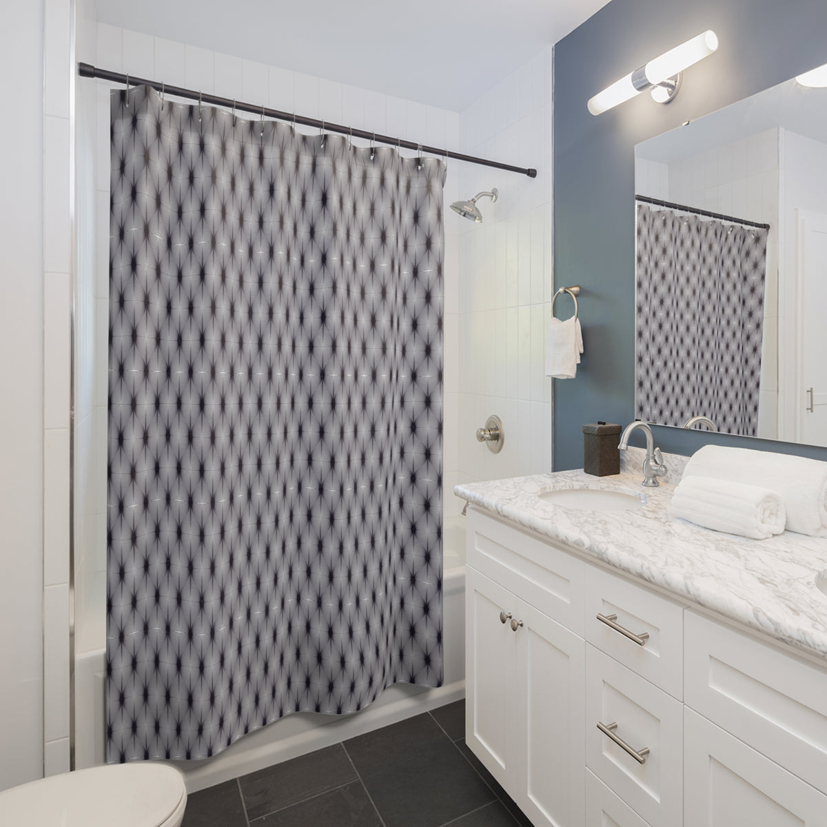 a modern bathroom with a white vanity, a gray and white patterned shower curtain, and a white sink with a marble countertop.