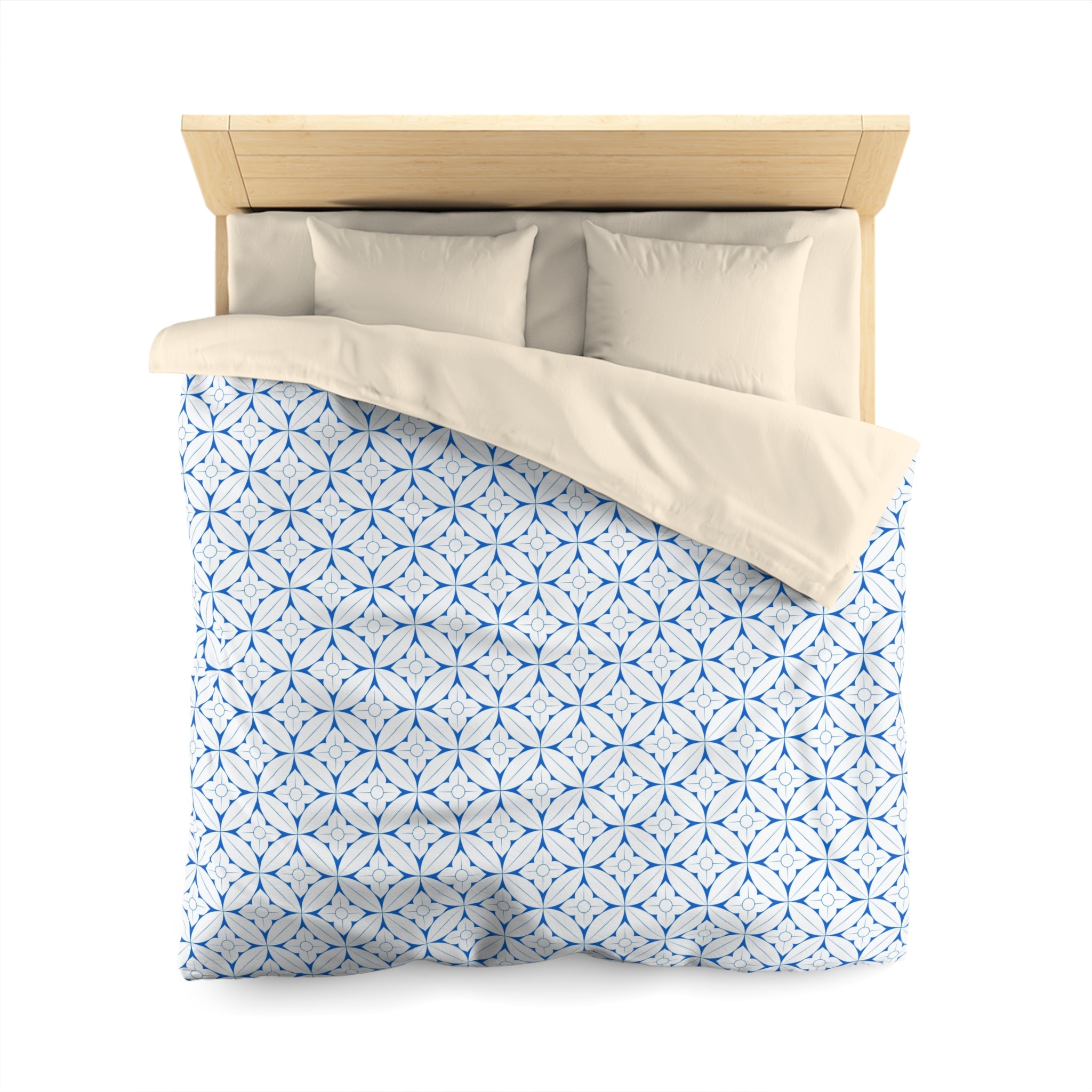 a neatly made bed with a blue and white patterned comforter and pillows.