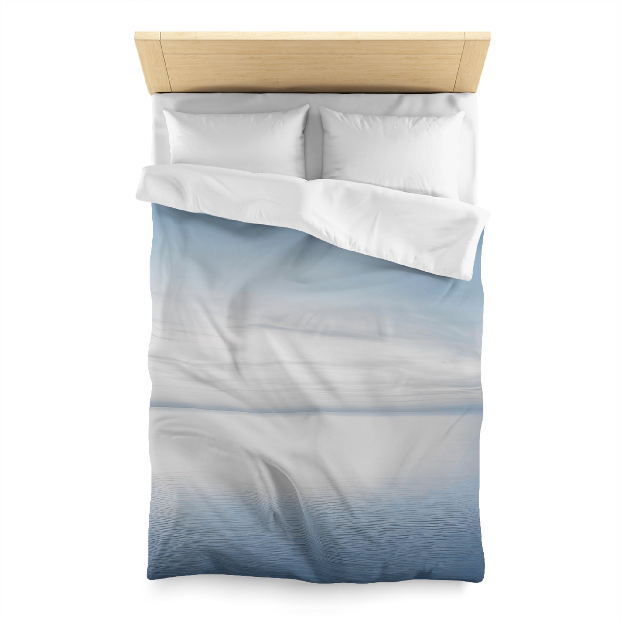 A neatly made bed with a blue and white patterned comforter and pillows.