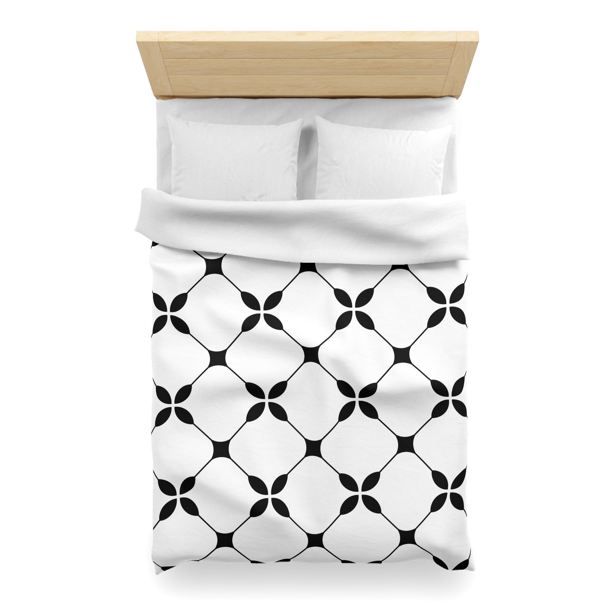 a neatly made bed with a white comforter and a black and white patterned blanket.