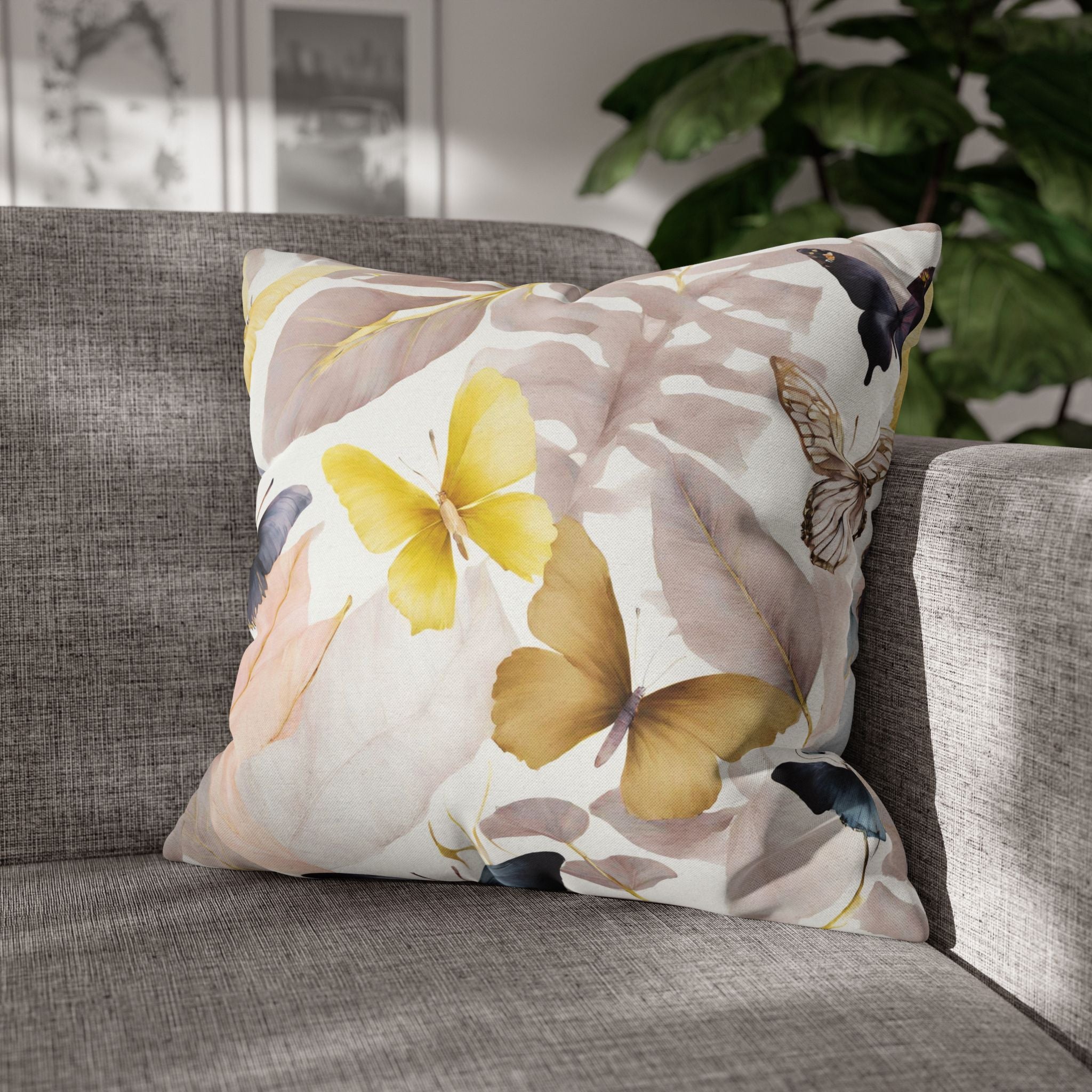 A gray sofa with a decorative throw pillow featuring a floral pattern of yellow and brown butterflies and leaves.