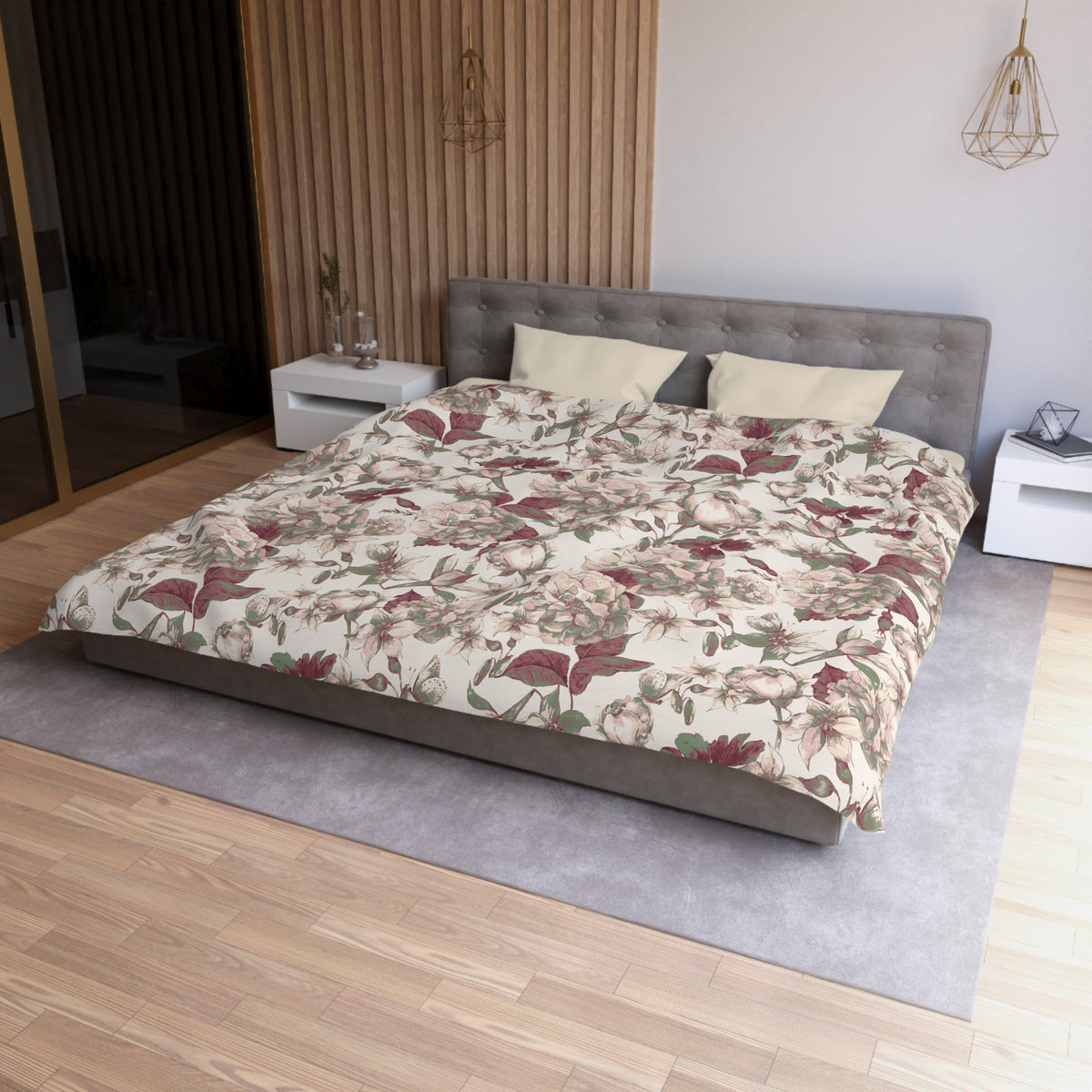 a modern bedroom with a large bed, a gray headboard, and a floral patterned comforter. The room has a wooden floor and white walls, creating a serene and elegant atmosphere.