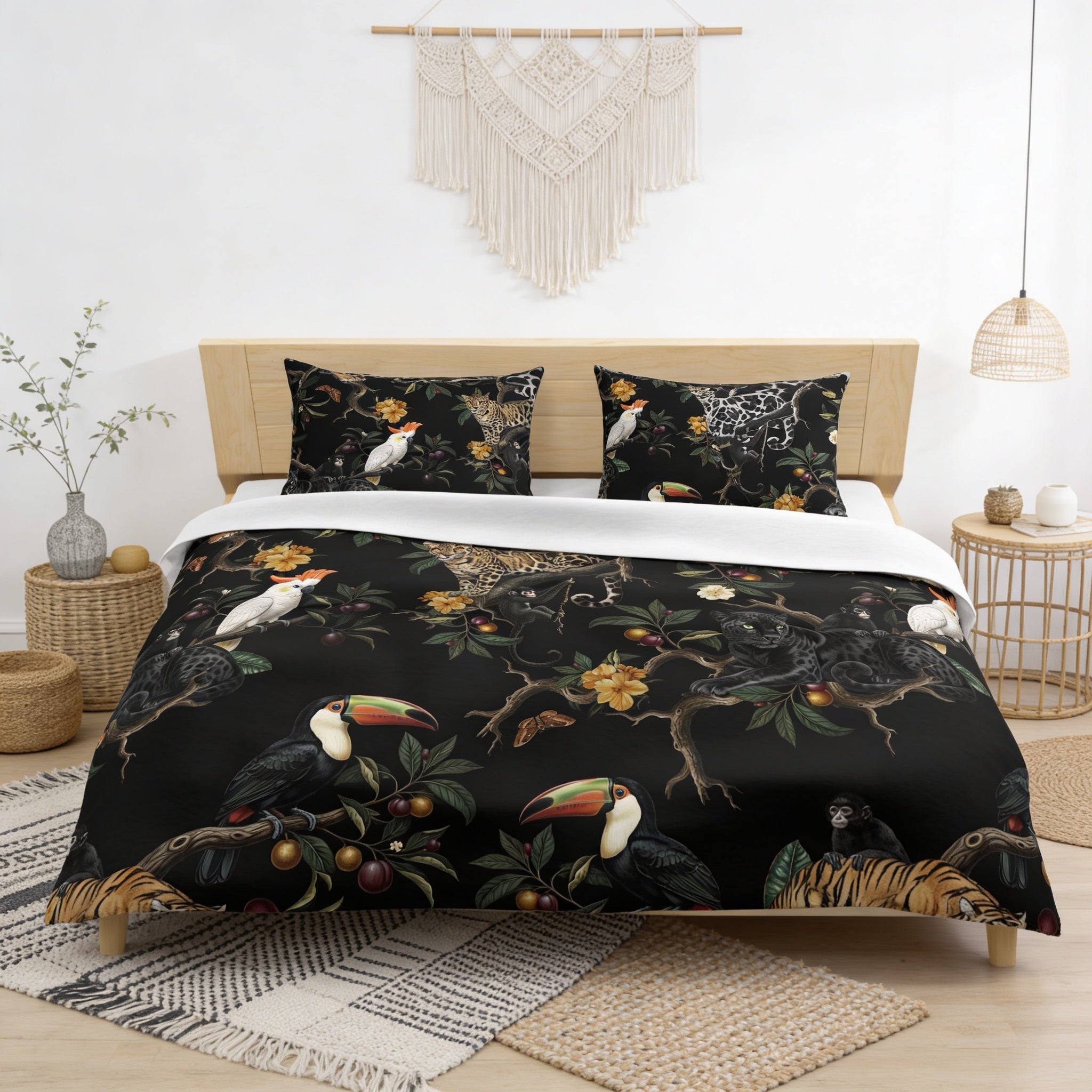 a bedroom with a bed adorned with a black and white tropical print duvet cover. The duvet cover is decorated with various tropical animals, such as a toucan, a tiger, and a parrot, creating a vibrant and nature-inspired design. The bed is set against a white wall, and there are additional decorative elements in the room, including a macrame wall hanging and a woven basket.