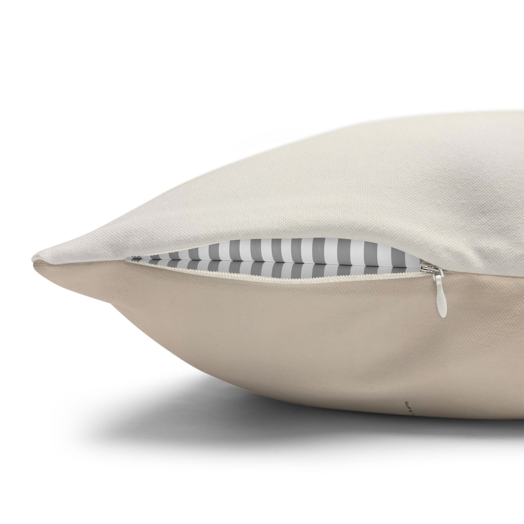A close-up view of a beige pillow with a white zipper visible inside.