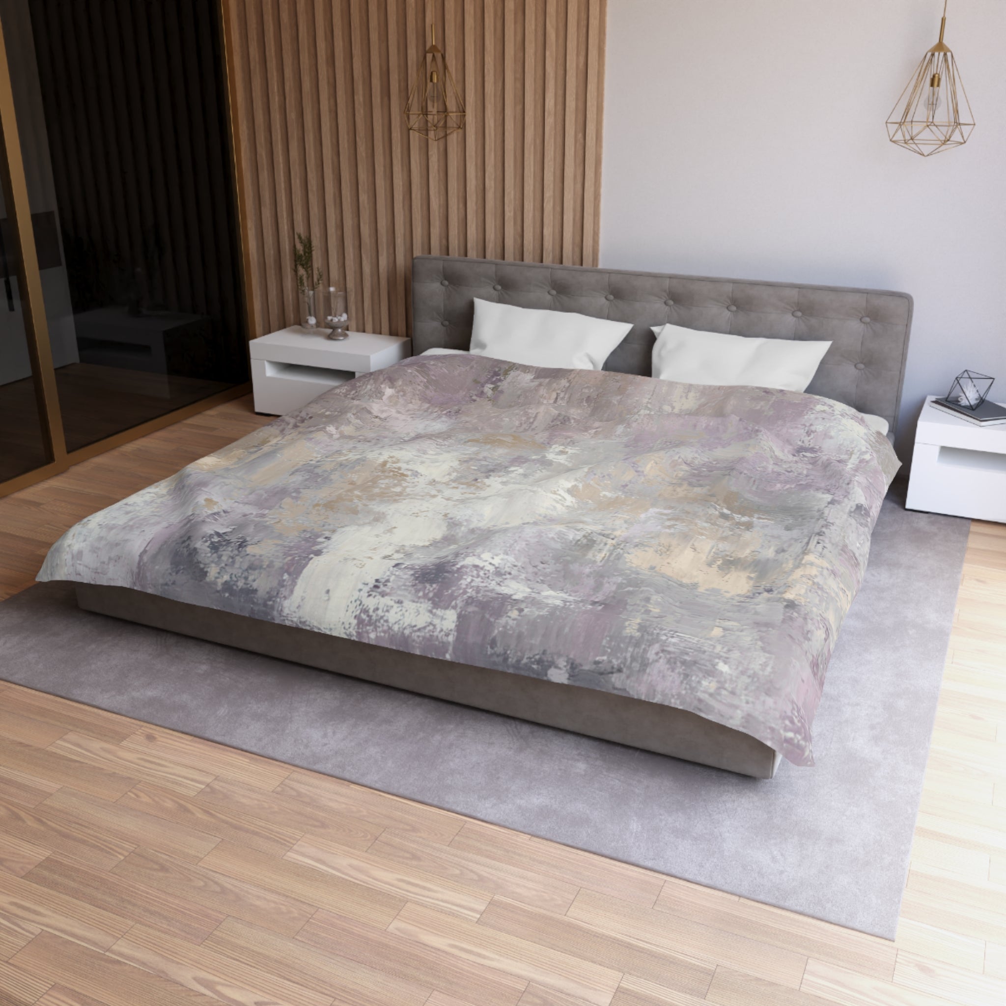 a modern bedroom with a large bed, a gray headboard, and a gray and white abstract patterned comforter. The room has a wooden floor and white nightstands on either side of the bed. There is a pendant light hanging above the bed, and a vase on one of the nightstands.
