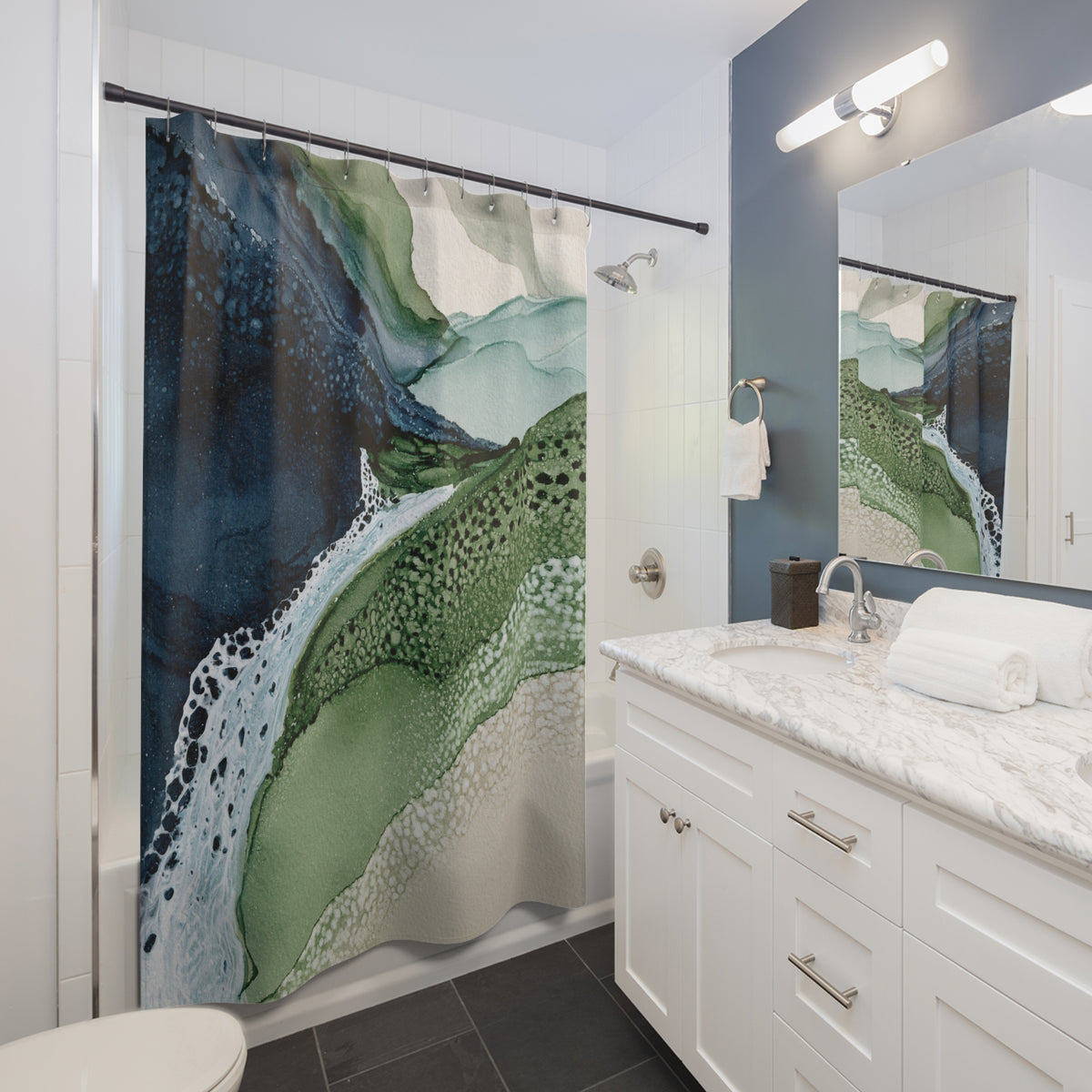 a modern bathroom with a large green and white abstract pattern on the shower curtain, a white sink with a marble countertop, and a mirror above the sink.