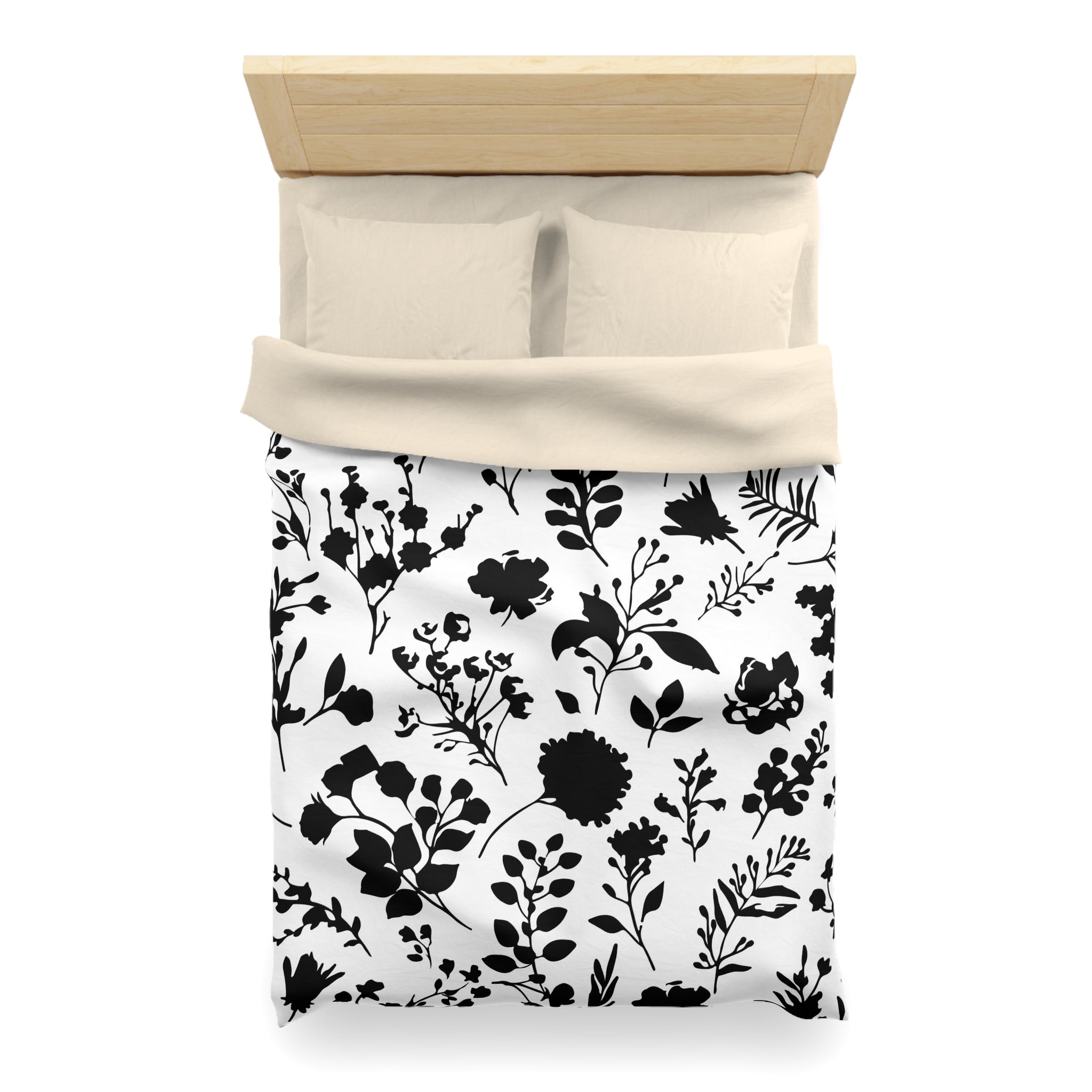 a neatly made bed with a black and white floral patterned comforter and pillows.