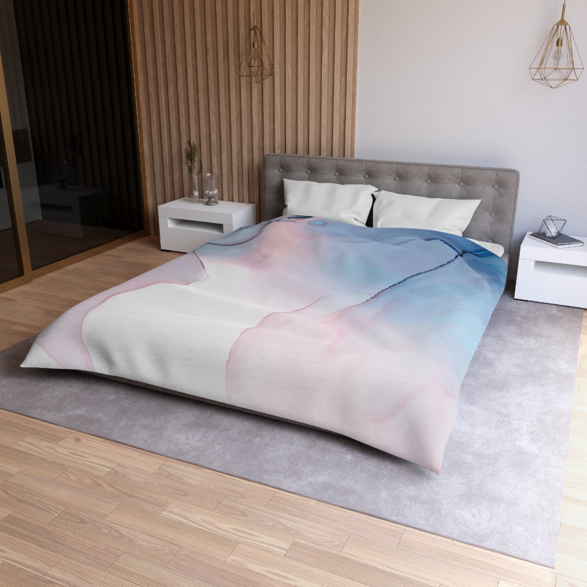 a modern bedroom with a large bed, a gray headboard, and a colorful abstract patterned comforter. The room has a wooden floor and white nightstands on either side of the bed.
