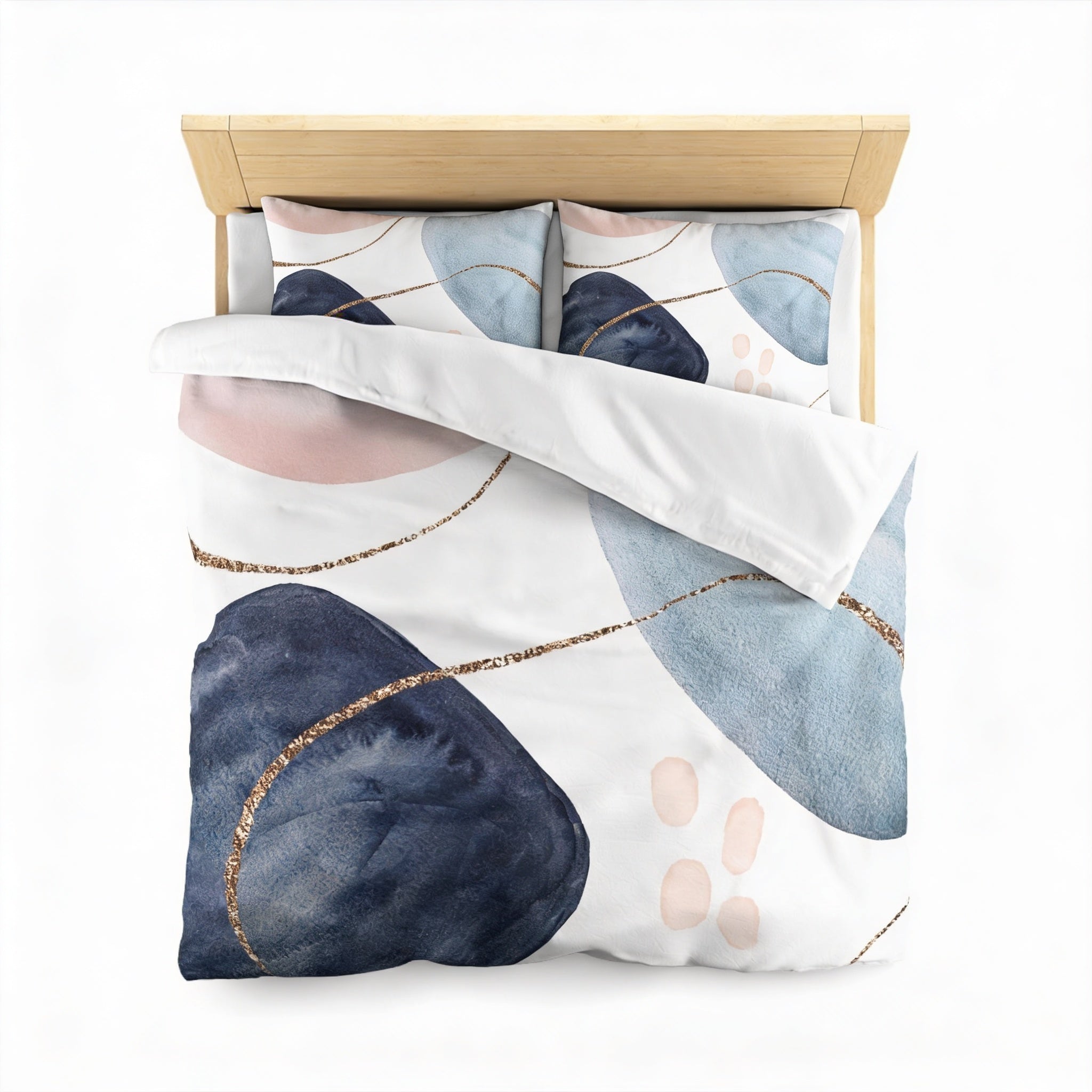 a bed with a white comforter and pillows, featuring a pattern of abstract shapes in shades of blue, pink, and white.