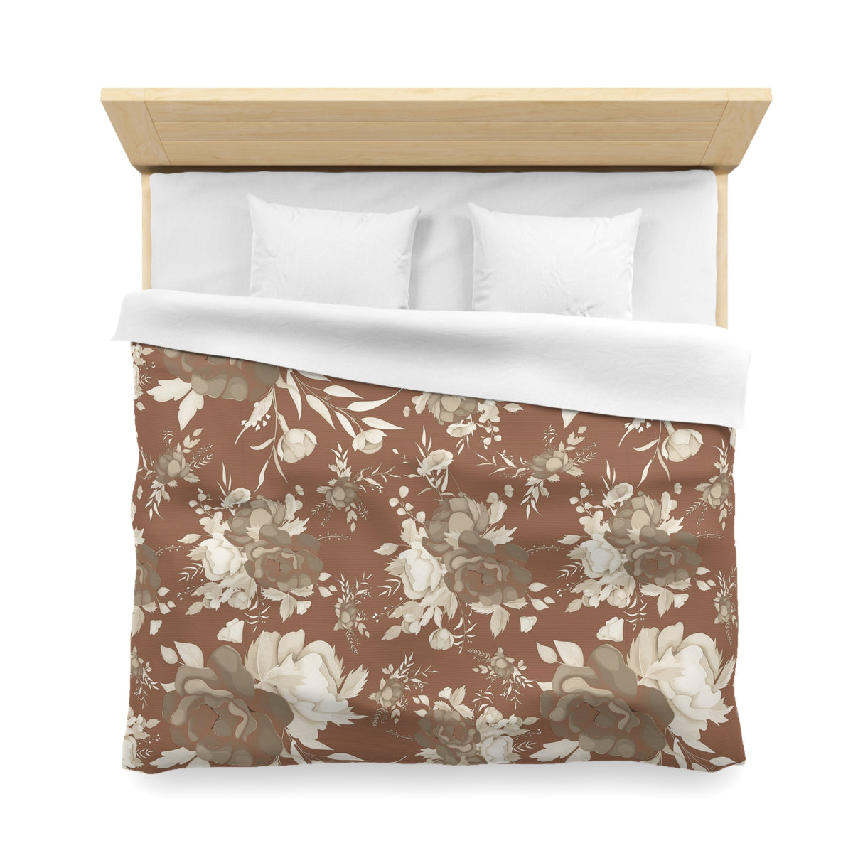 a neatly made bed with a floral patterned comforter and two white pillows.