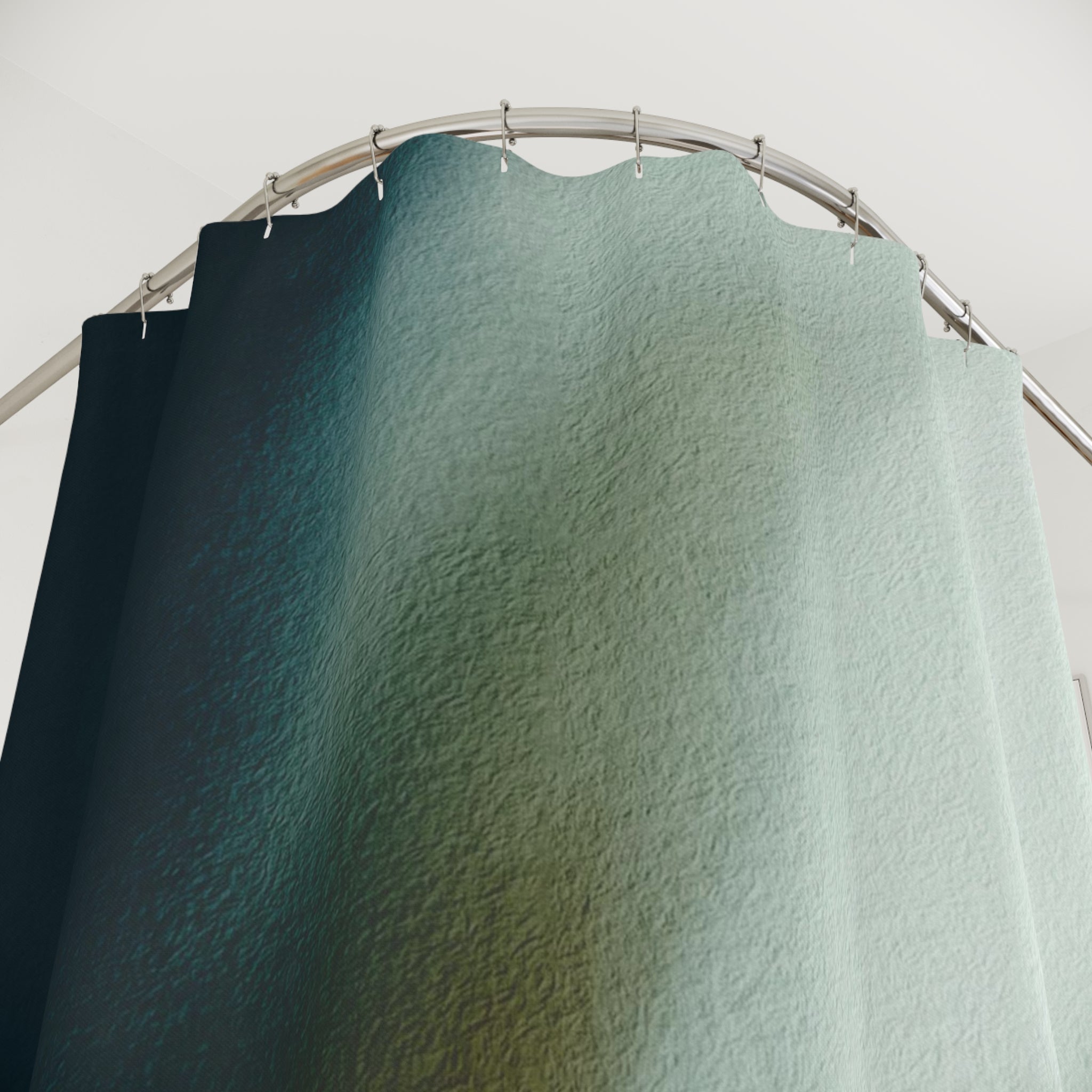 a shower curtain with a gradient of colors, transitioning from dark blue at the top to a lighter green at the bottom. The curtain is hanging from a rod, creating a visually appealing and textured appearance.