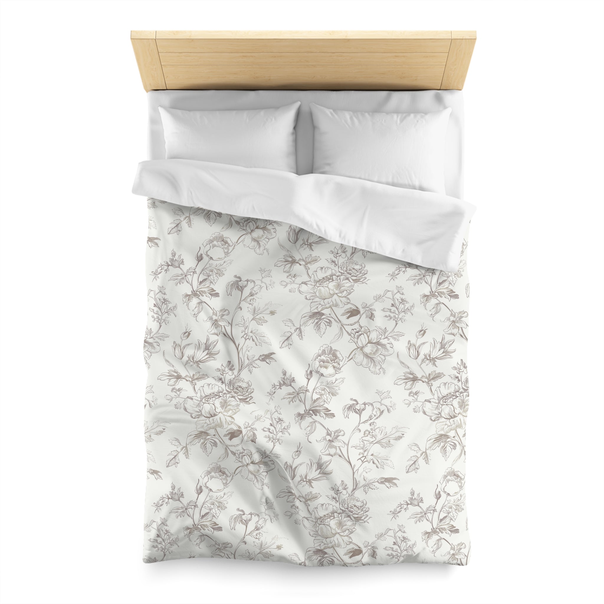 a neatly made bed with a floral patterned comforter and pillows.