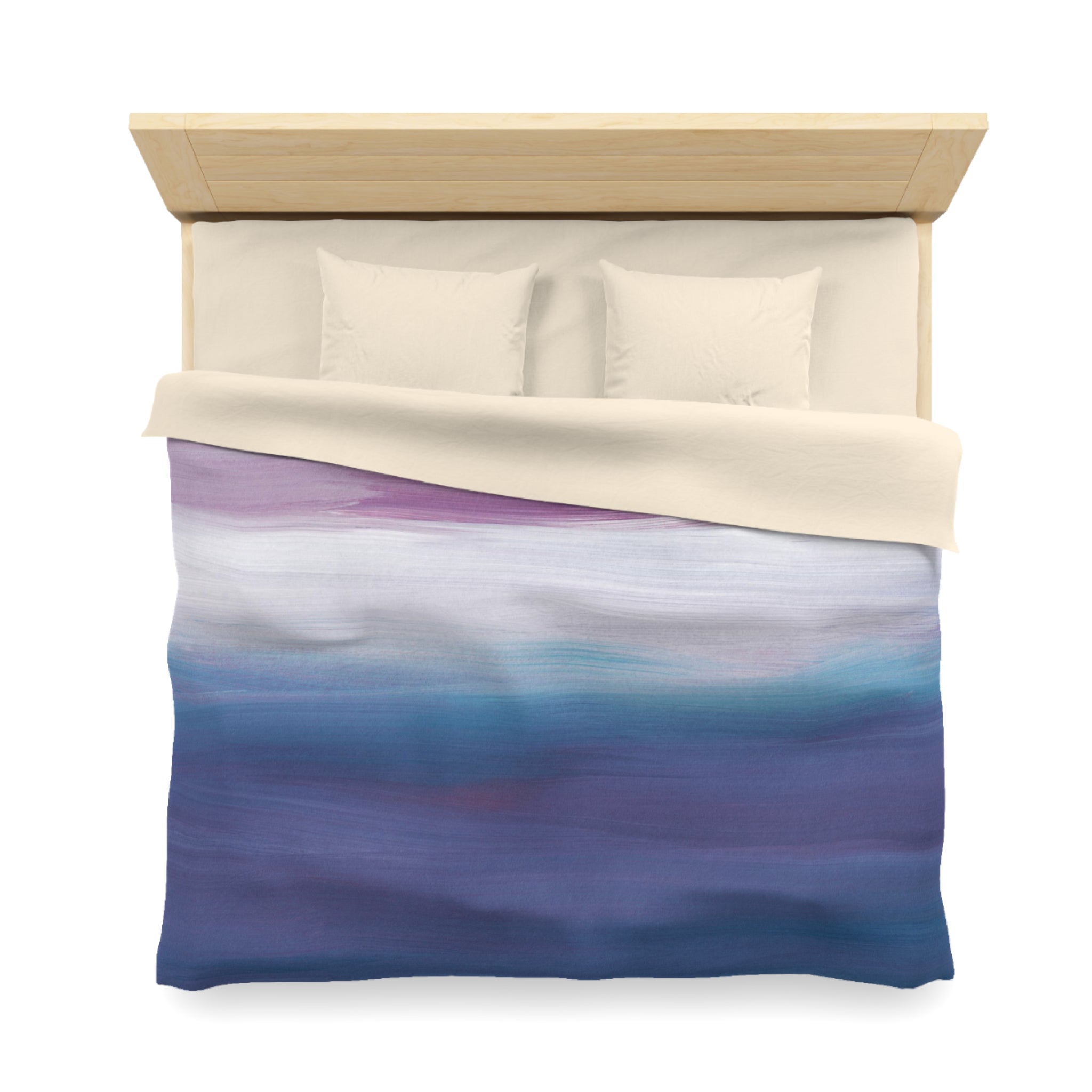 a neatly made bed with a blue and white gradient comforter and two white pillows.