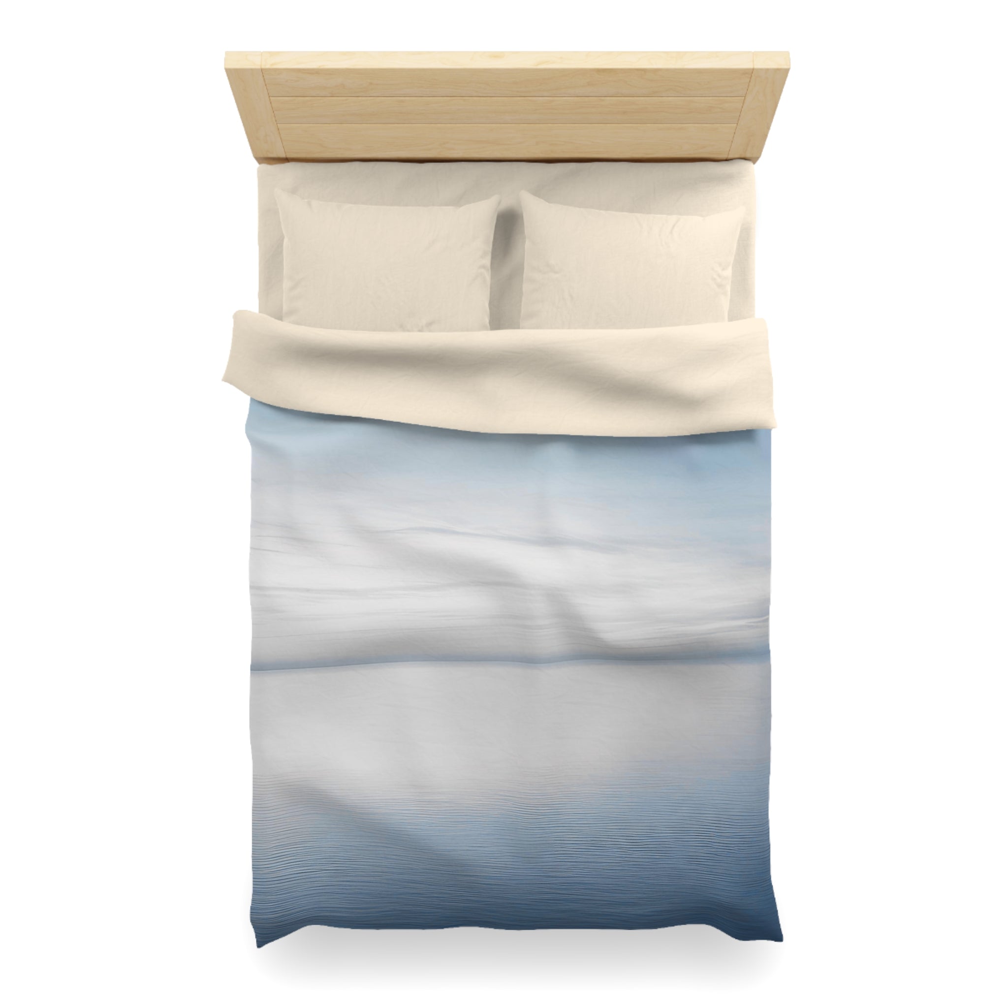 A neatly made bed with a blue and white patterned comforter and pillows.