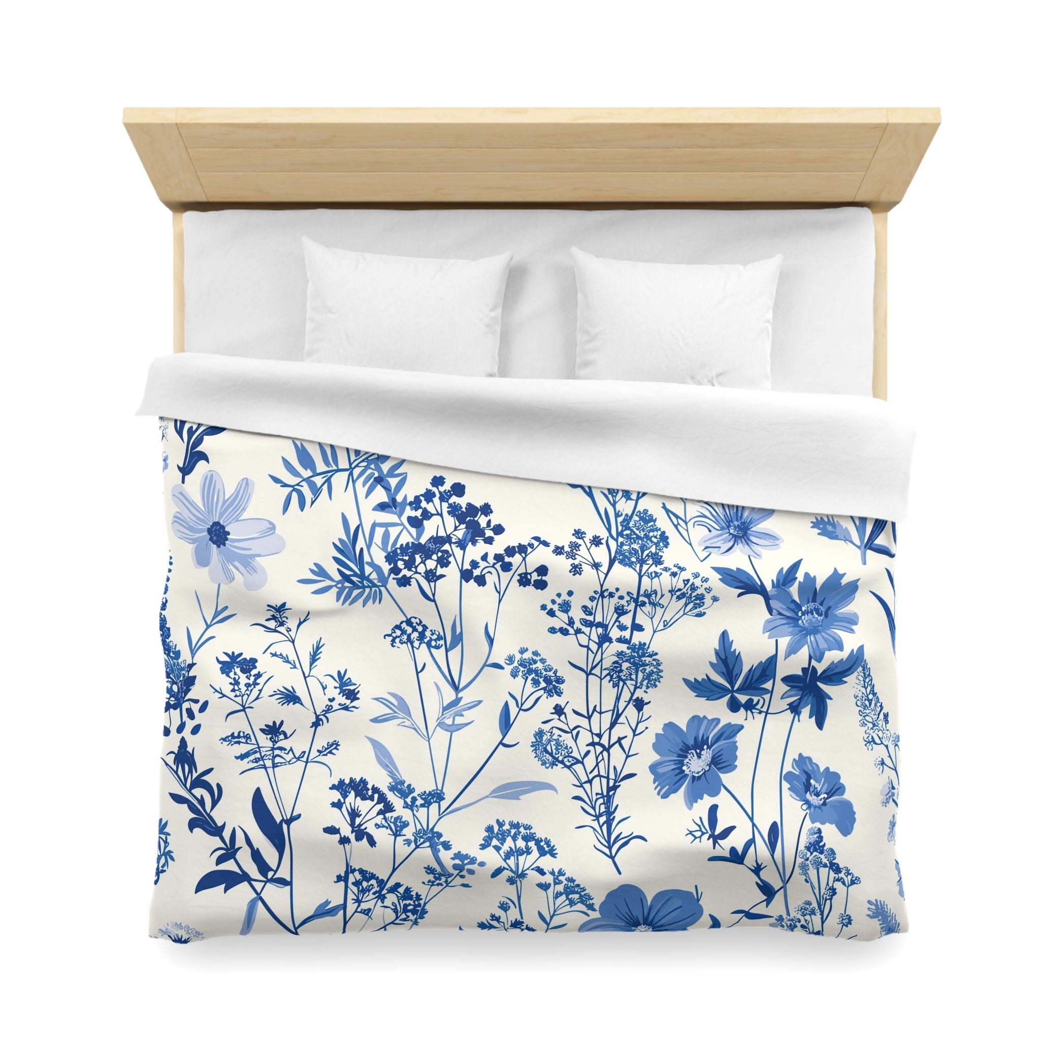 a neatly made bed with a blue and white floral patterned duvet cover and pillows.