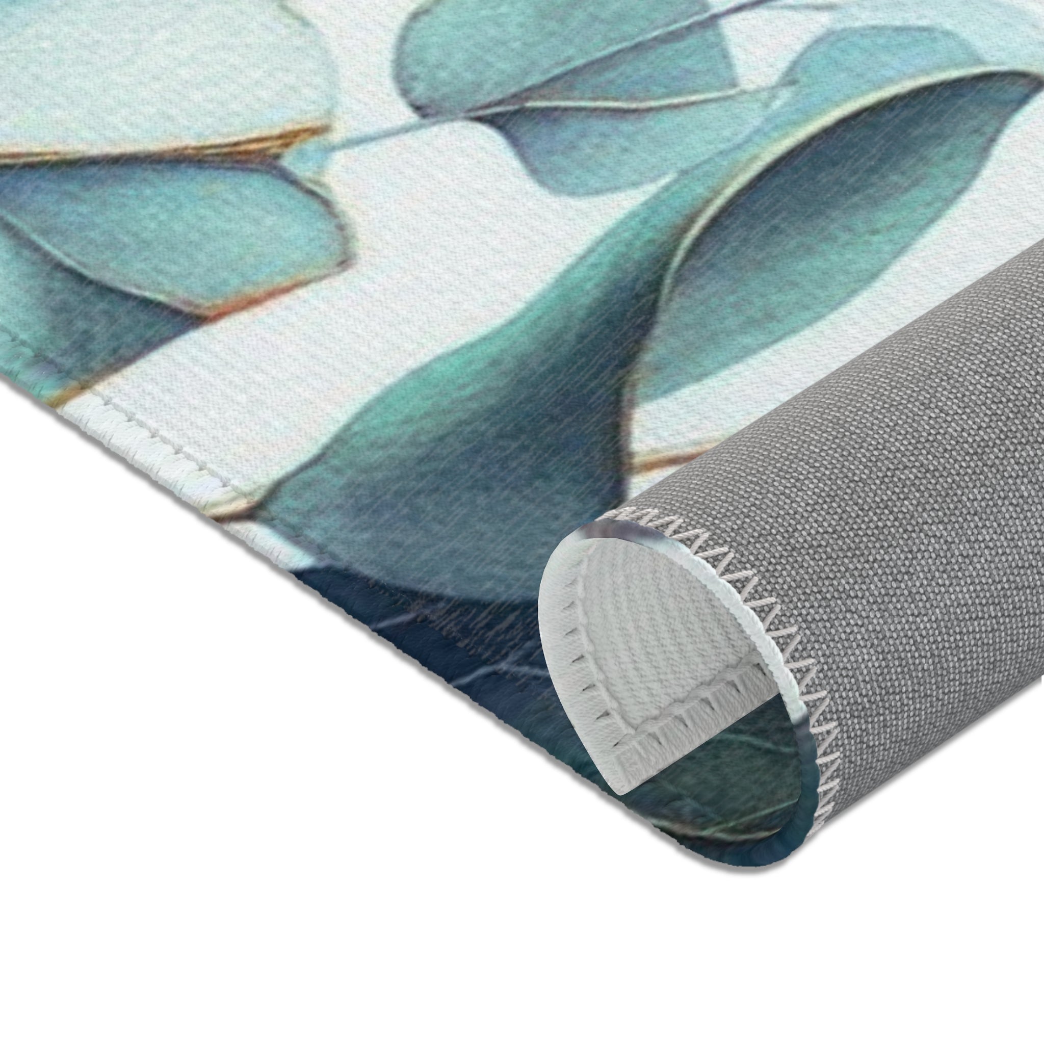 a close-up view of a rolled-up rug with a pattern of green leaves and a blue background.