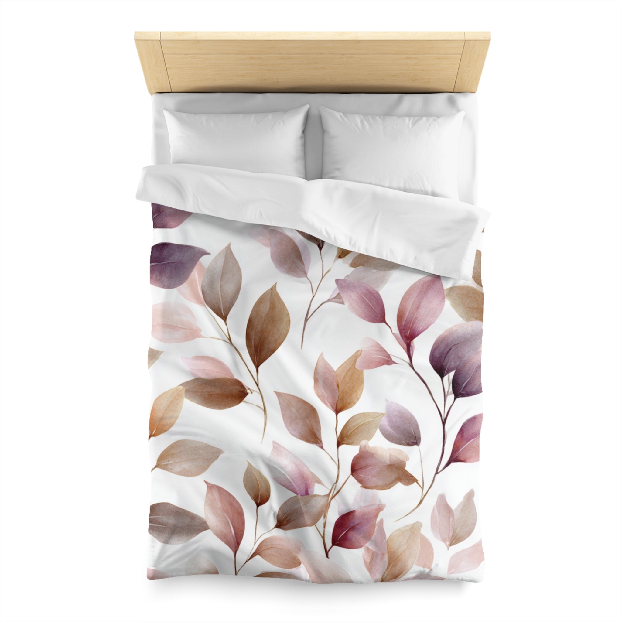 a bed with a white comforter and a leaf-patterned duvet cover.