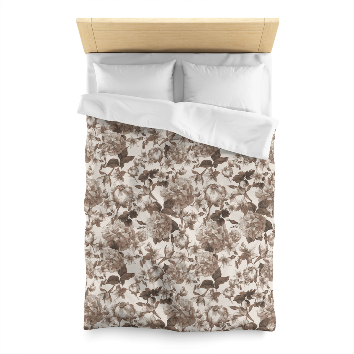 a neatly made bed with a floral print comforter and two white pillows.