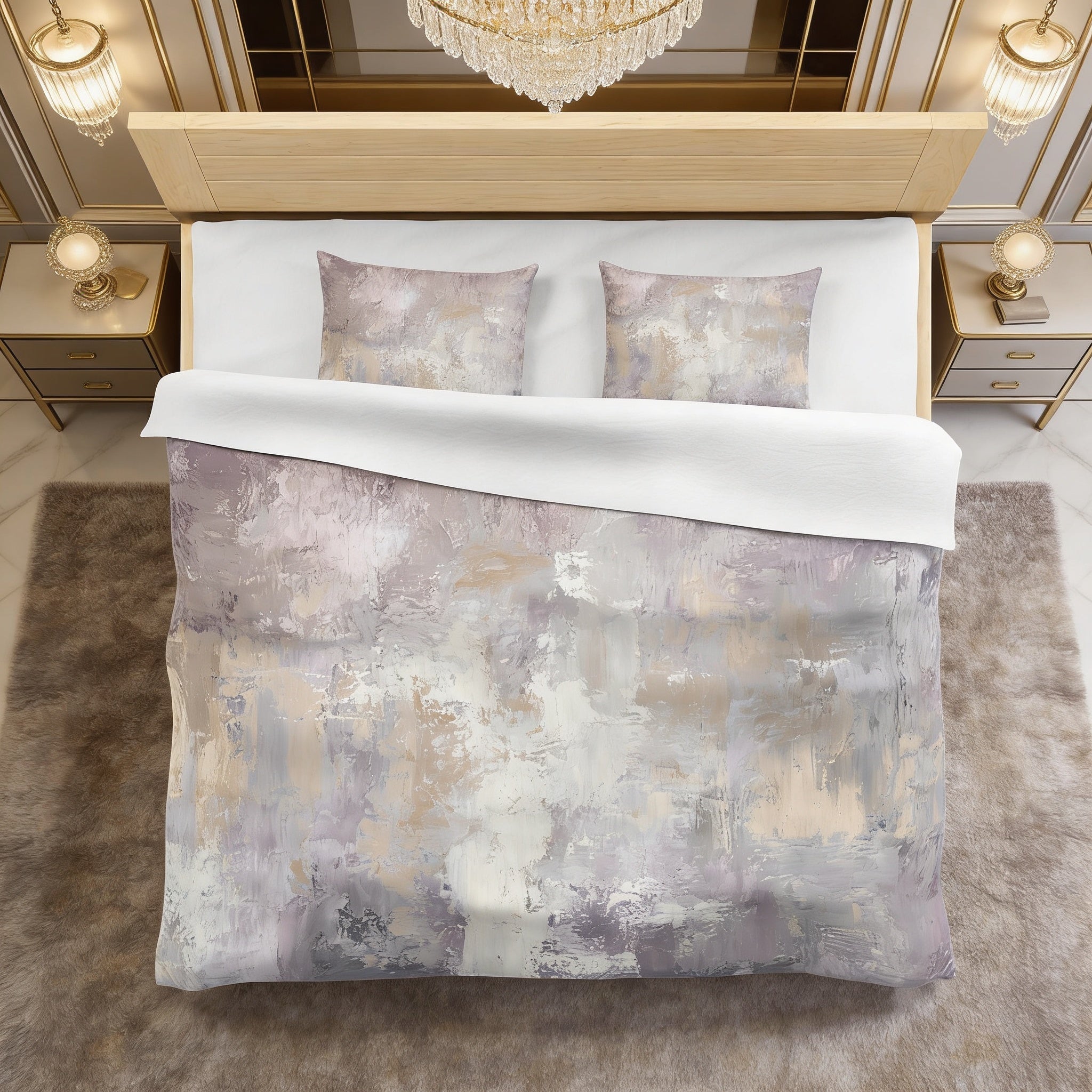 a luxurious bedroom with a large bed covered in a gray and white abstract patterned comforter. The bed is framed by a wooden headboard and flanked by two nightstands with gold-colored lamps on either side. The room has a plush, beige carpet and a chandelier hanging from the ceiling, creating an elegant and sophisticated atmosphere.