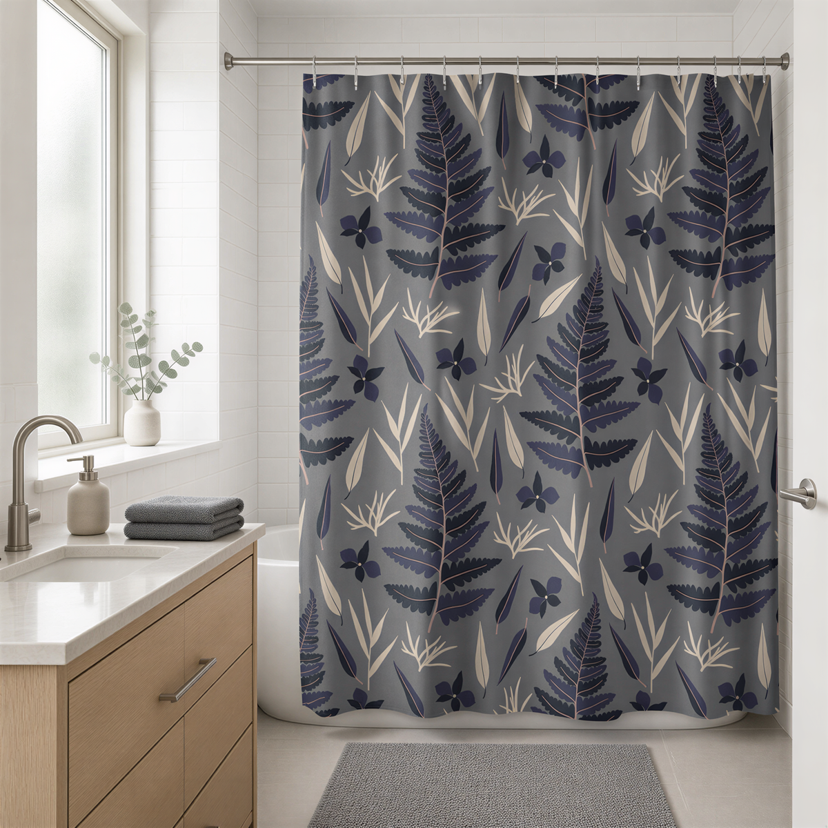 a bathroom with a shower curtain adorned with a pattern of blue and white ferns and other plants. The shower curtain is hanging from a rod, and there is a sink and a window in the background.