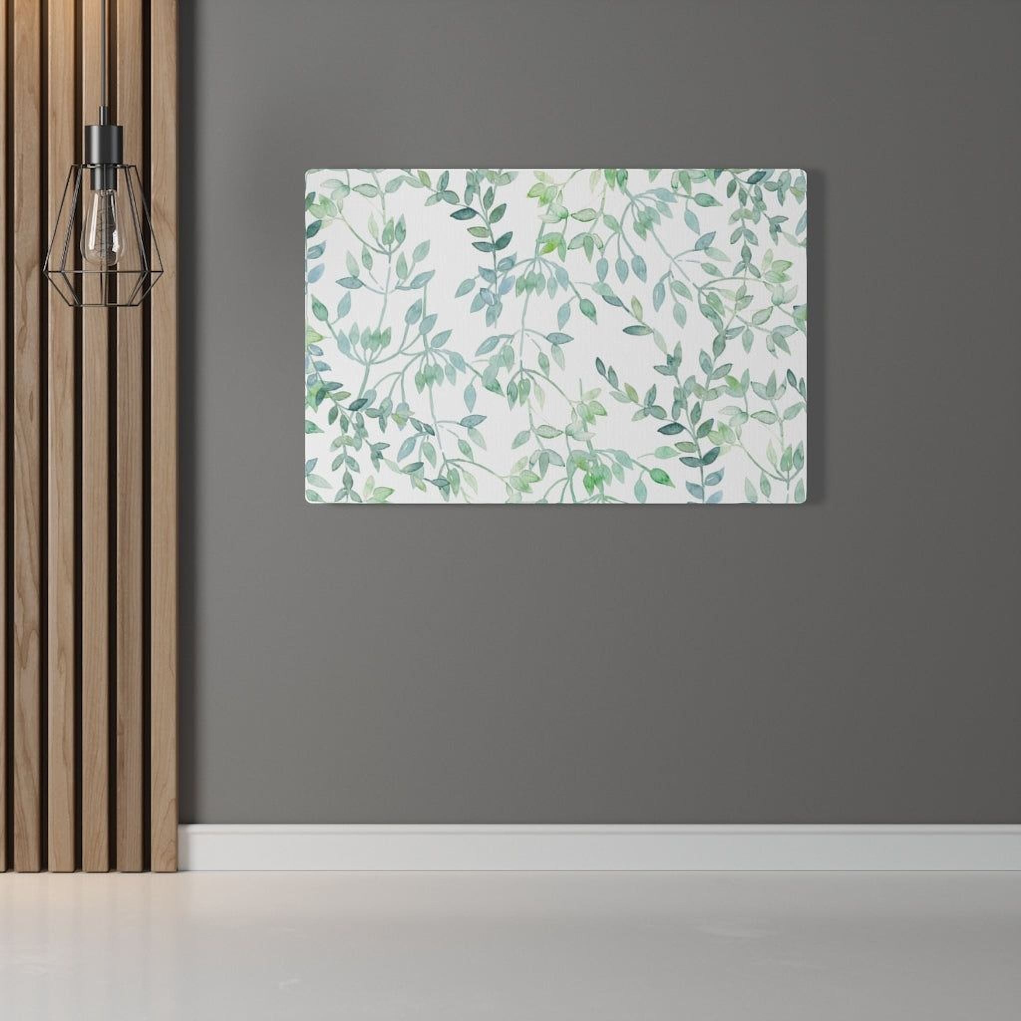 a large canvas print with a green leaf pattern hanging on a gray wall.