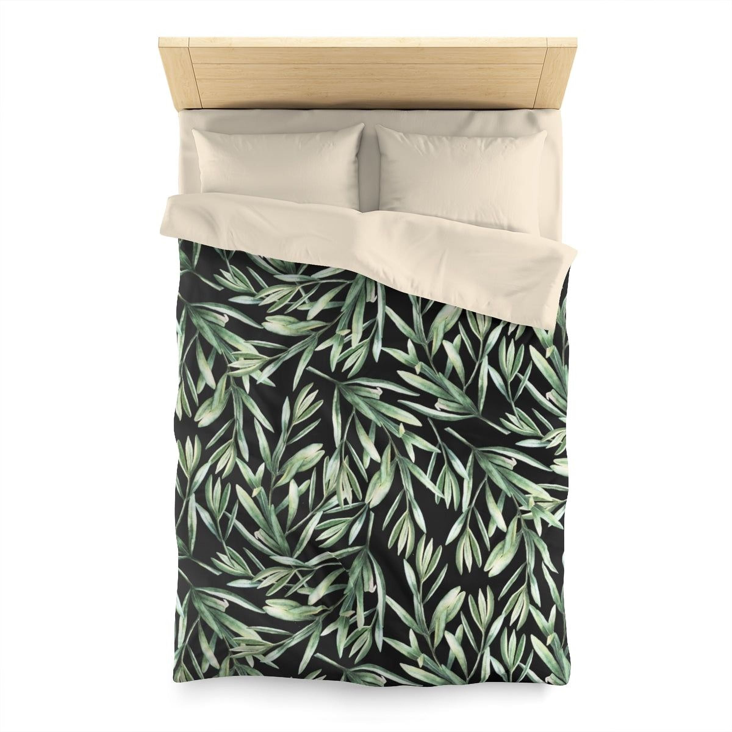 a bed with a black and green leafy patterned comforter and pillows.