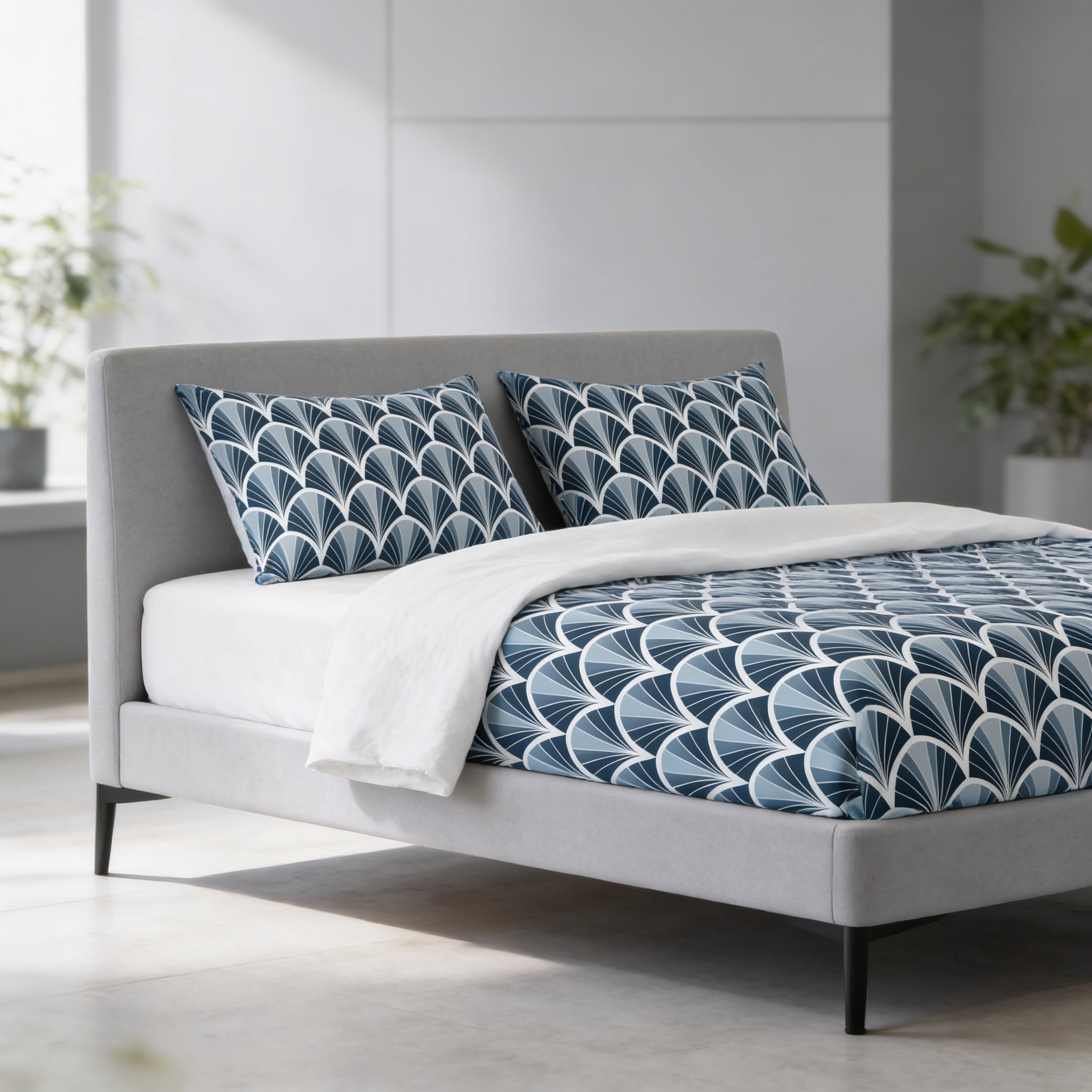 a modern bedroom with a gray headboard and a bed with a blue and white patterned comforter and pillows. The room has a minimalist and clean design, with a white wall and a window providing natural light.