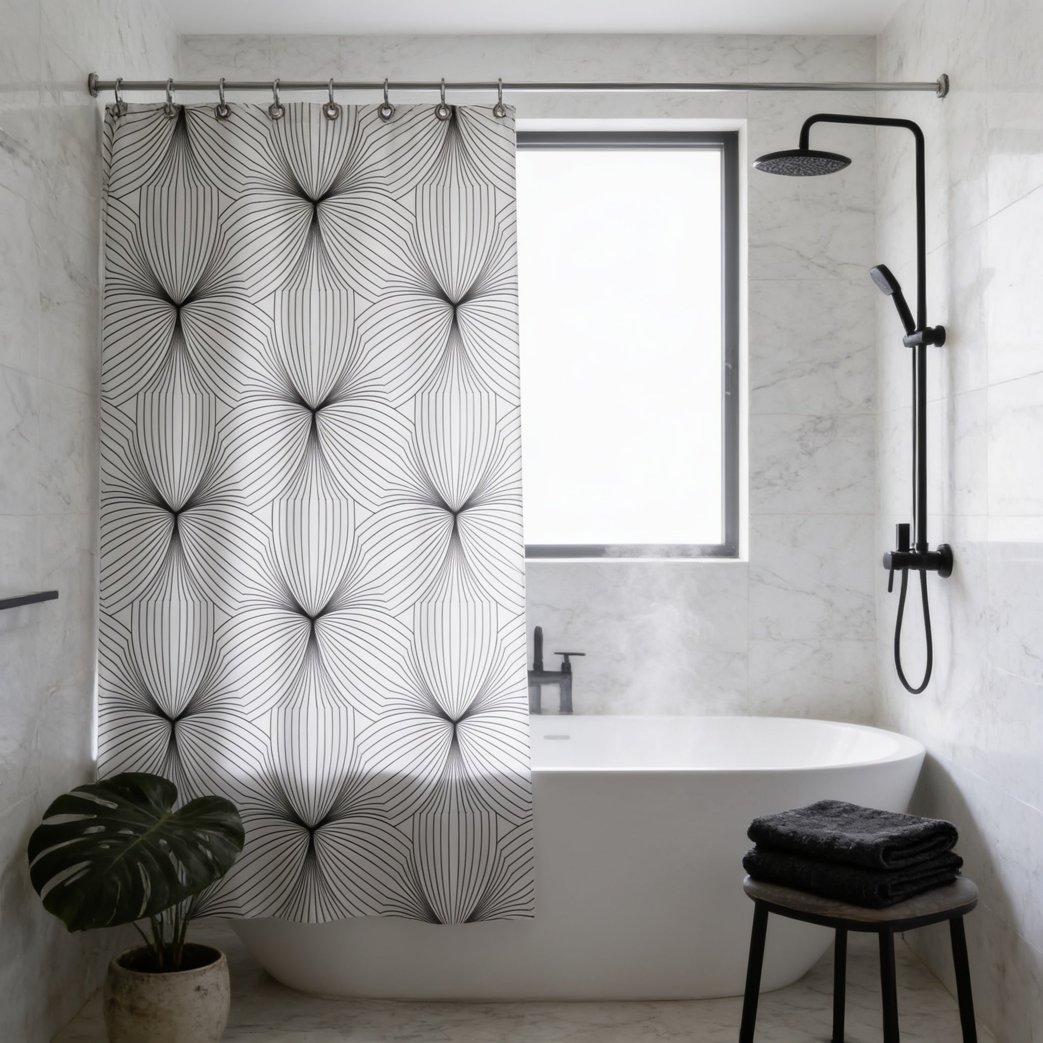 a modern bathroom with a white bathtub, a black and white patterned shower curtain, a black towel, and a potted plant.