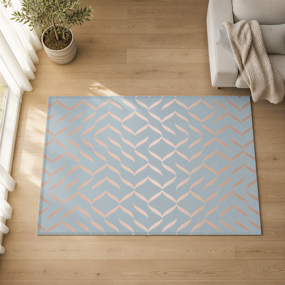 a blue and orange patterned rug on a wooden floor, with a white couch and a potted plant in the background.