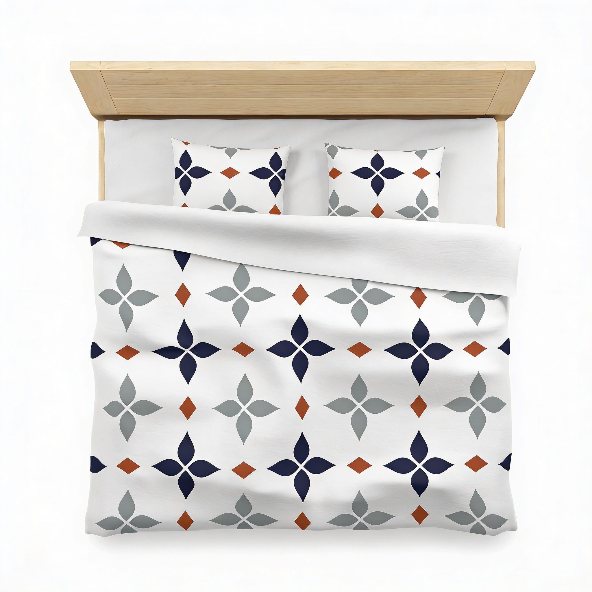 a neatly made bed with a white comforter and pillows, featuring a repeating pattern of blue and gray geometric shapes.