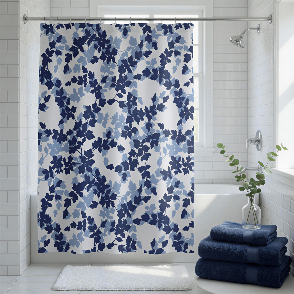 a bathroom with a shower curtain adorned with a blue leaf pattern, a white bathtub, and a stack of blue towels. A vase of greenery is placed on the edge of the bathtub, adding a touch of nature to the space.