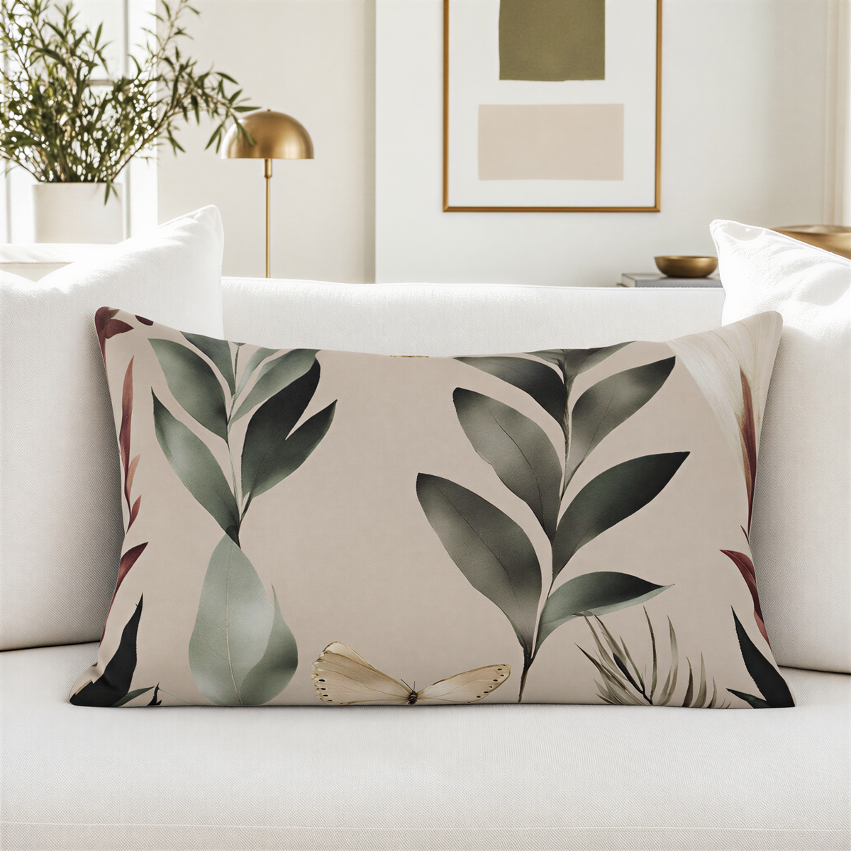 a white sofa with a decorative pillow featuring a leafy plant design.