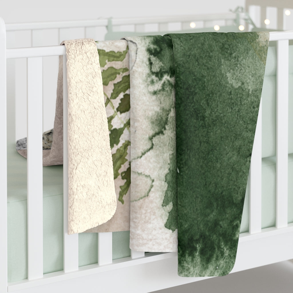 Black, ivory and forest green boho floral throw blanket on a bed