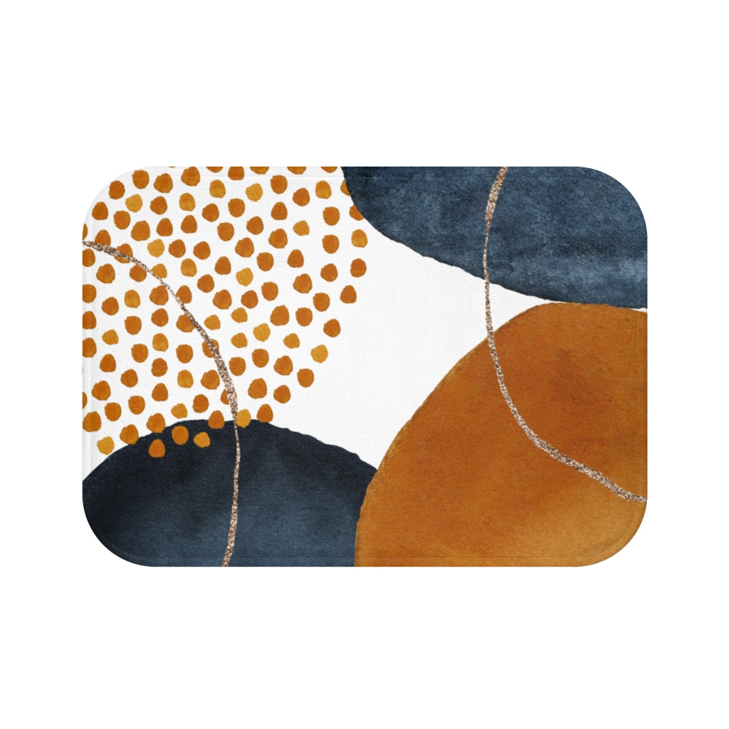 Navy blue and burnt orange boho bath mat styled by a bathtub