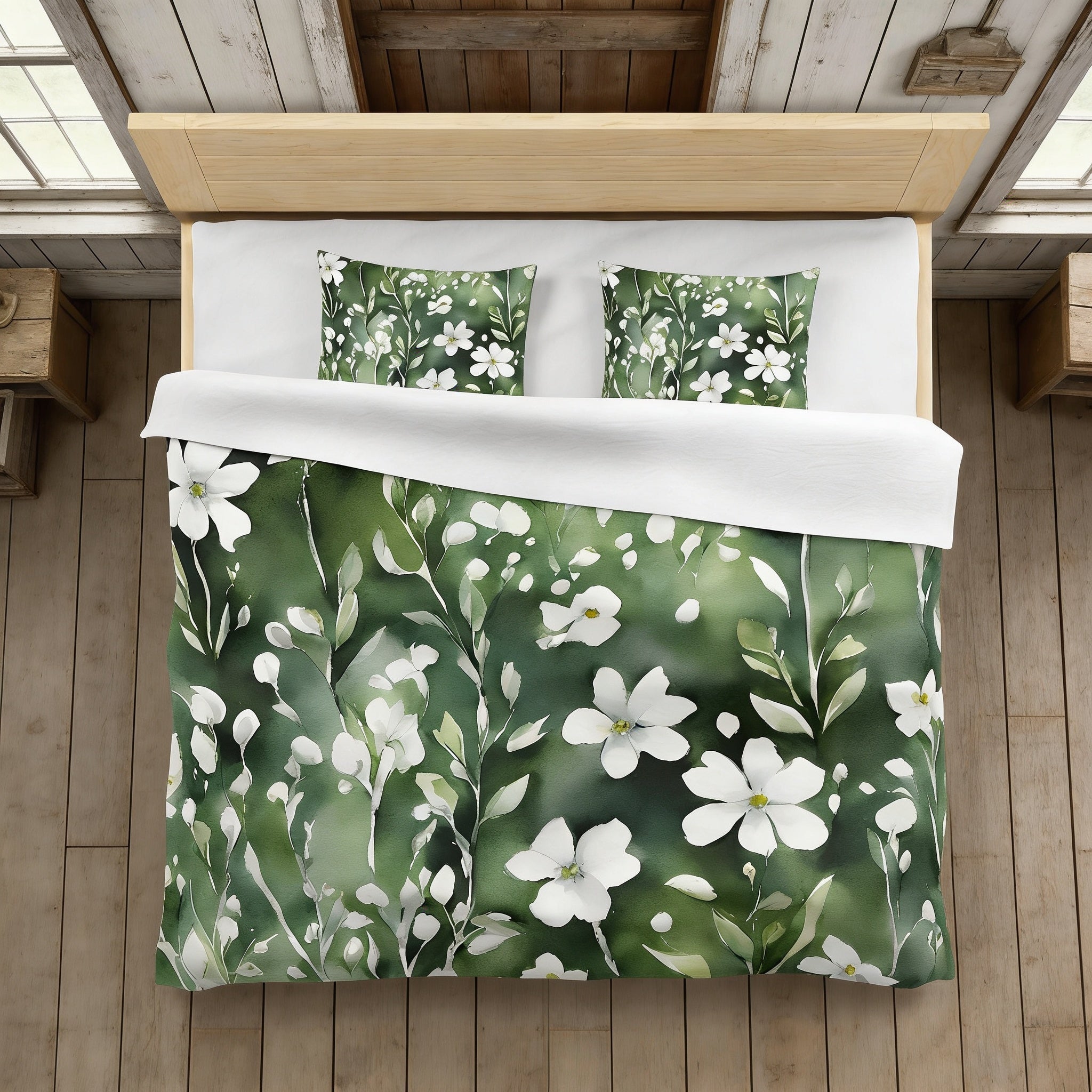 a bed with a green and white floral print duvet cover and matching pillows.