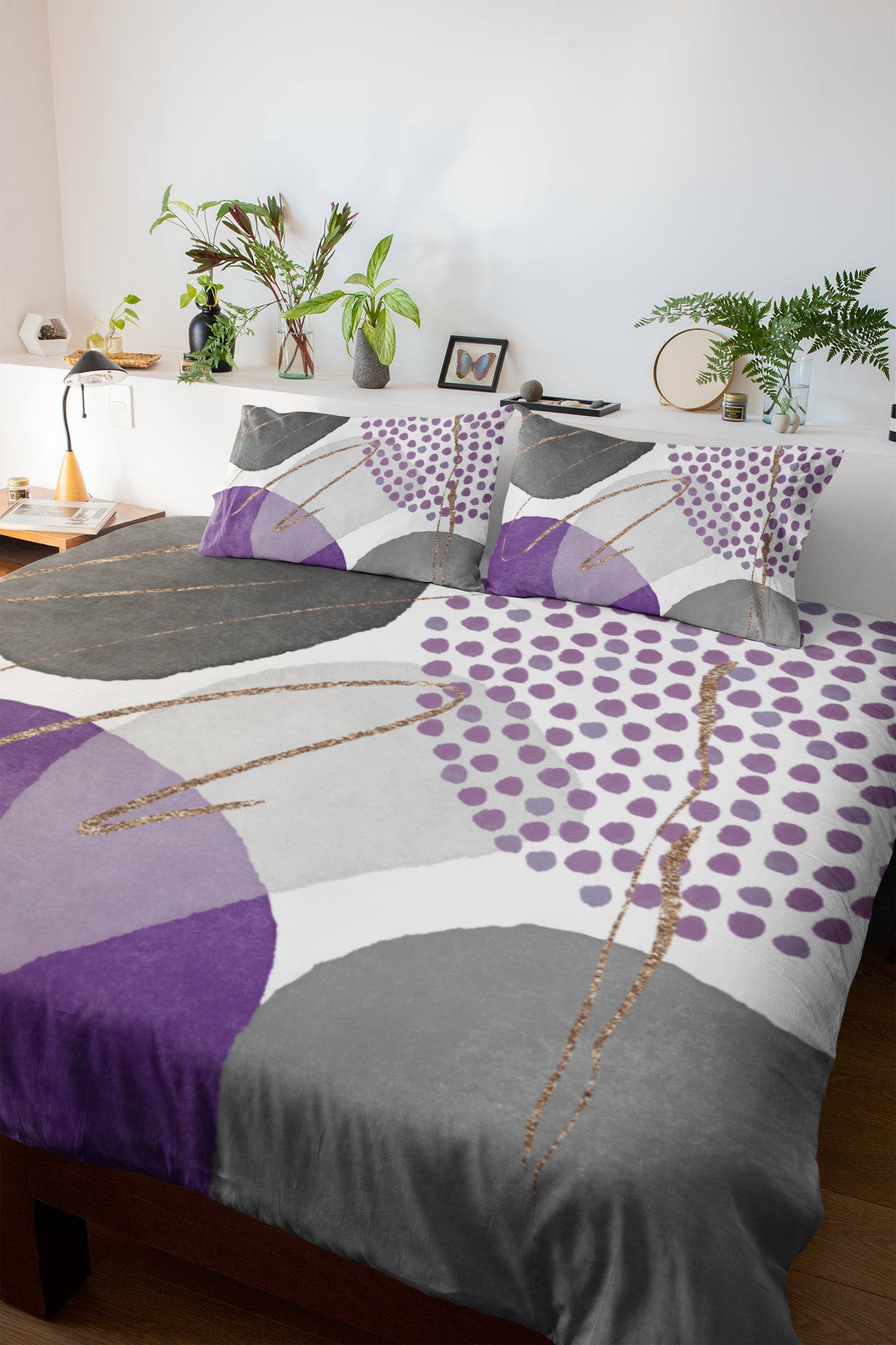 a bed covered in a purple and grey comforter