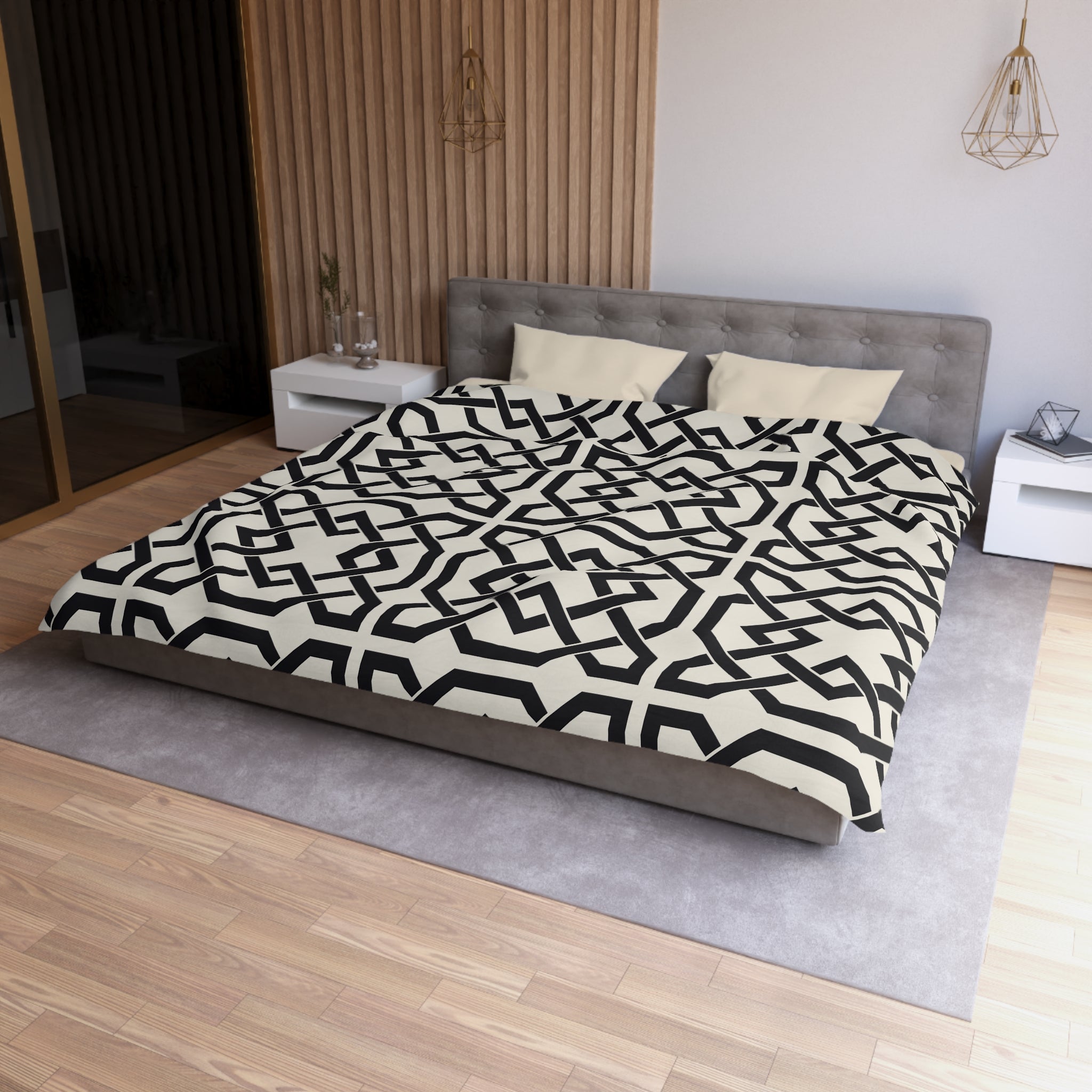 a modern bedroom with a large bed featuring a black and white geometric patterned comforter. The bed is positioned against a wall with a wooden panel, and there are two nightstands on either side of the bed. The room has a minimalist and contemporary design, with a gray rug on the floor and a wooden floor.