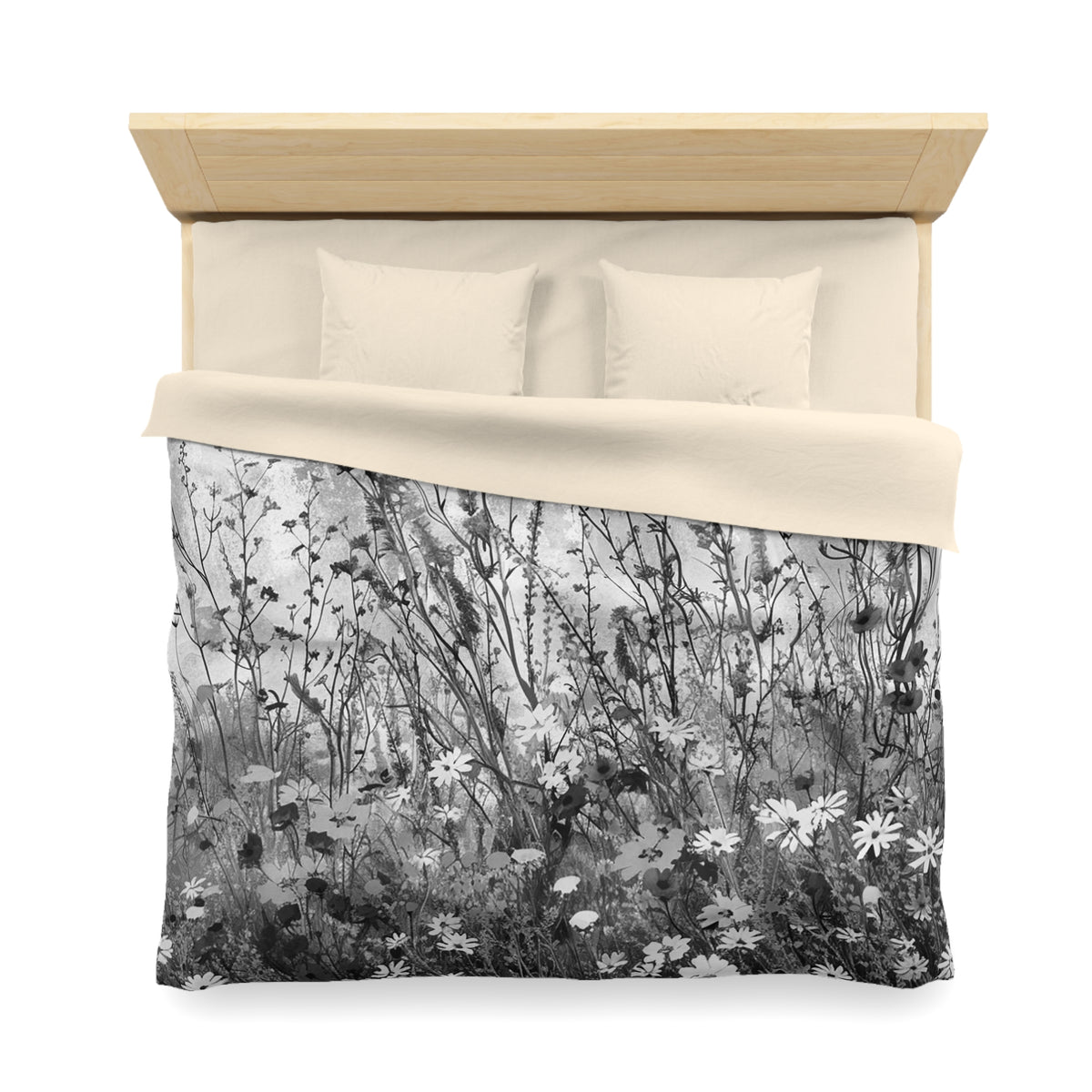 a bed with a black and white floral patterned comforter and pillows.