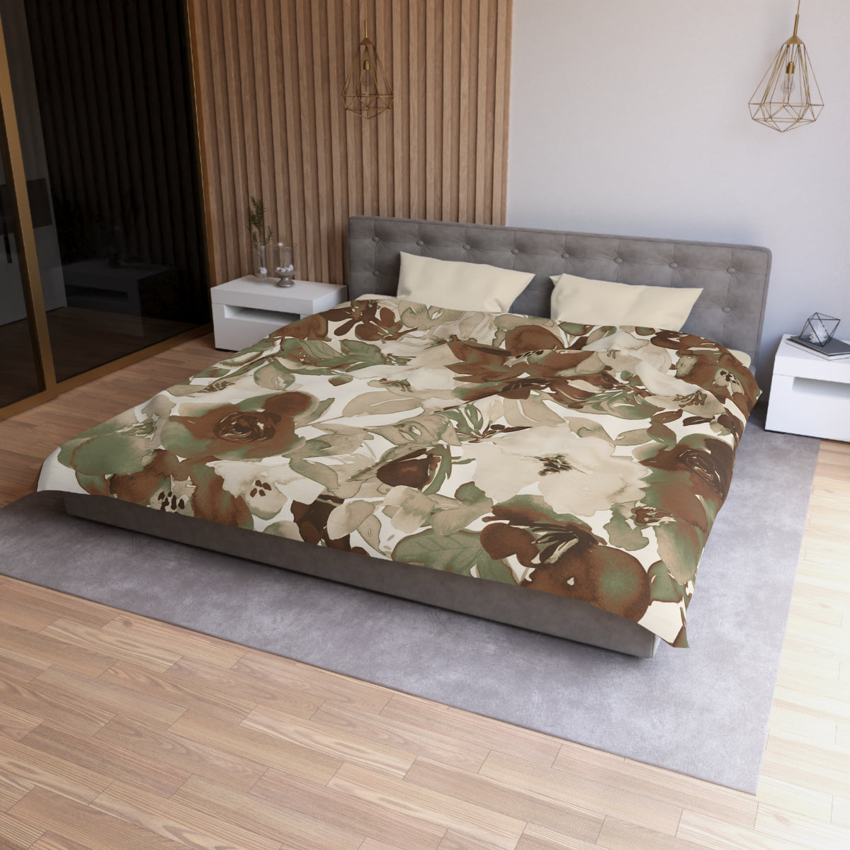 a modern bedroom with a large bed covered in a floral print comforter. The bed is positioned against a wall with a wooden panel. The room has a minimalist design, with a gray headboard and white nightstands. There is a pendant light hanging above the bed, and a vase on one of the nightstands. The overall color scheme of the room is neutral, with the floral print adding a touch of nature and warmth to the space.
